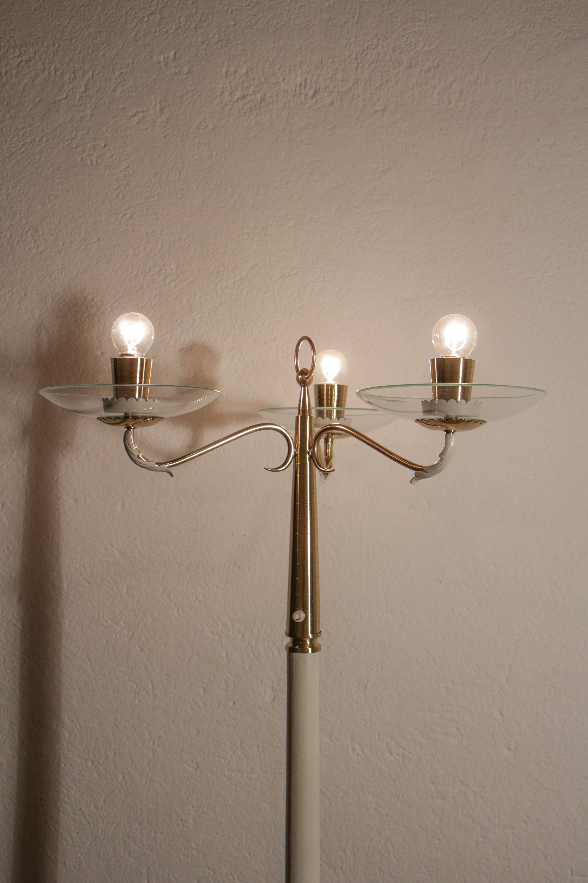 Meravigliosa lampada da terra italiana del Mid-Century Modern attribuita a Pietro Chiesa, realizzata negli anni Quaranta. Struttura in ottone lucido, legno di frassino e alluminio verniciato avorio. La lampada con sorgenti curve ha tre luci in
