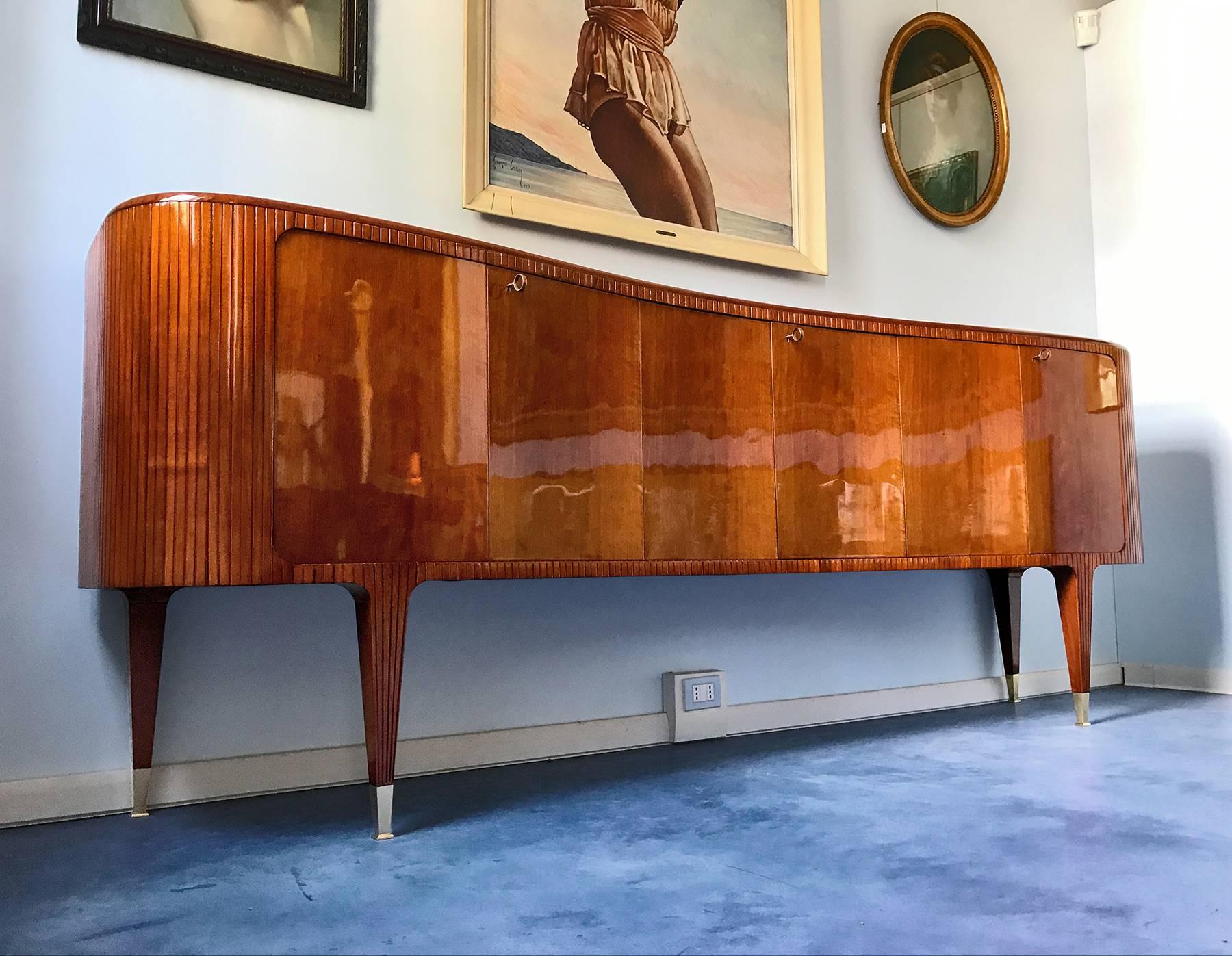 Very impressive and stylish walnut sideboard attributed to Guglielmo Ulrich by one of the most important auction houses in the world.
It's a very rare item with unique design given by the amazing 'wave' shape of the cabinet.
It's a midcentury