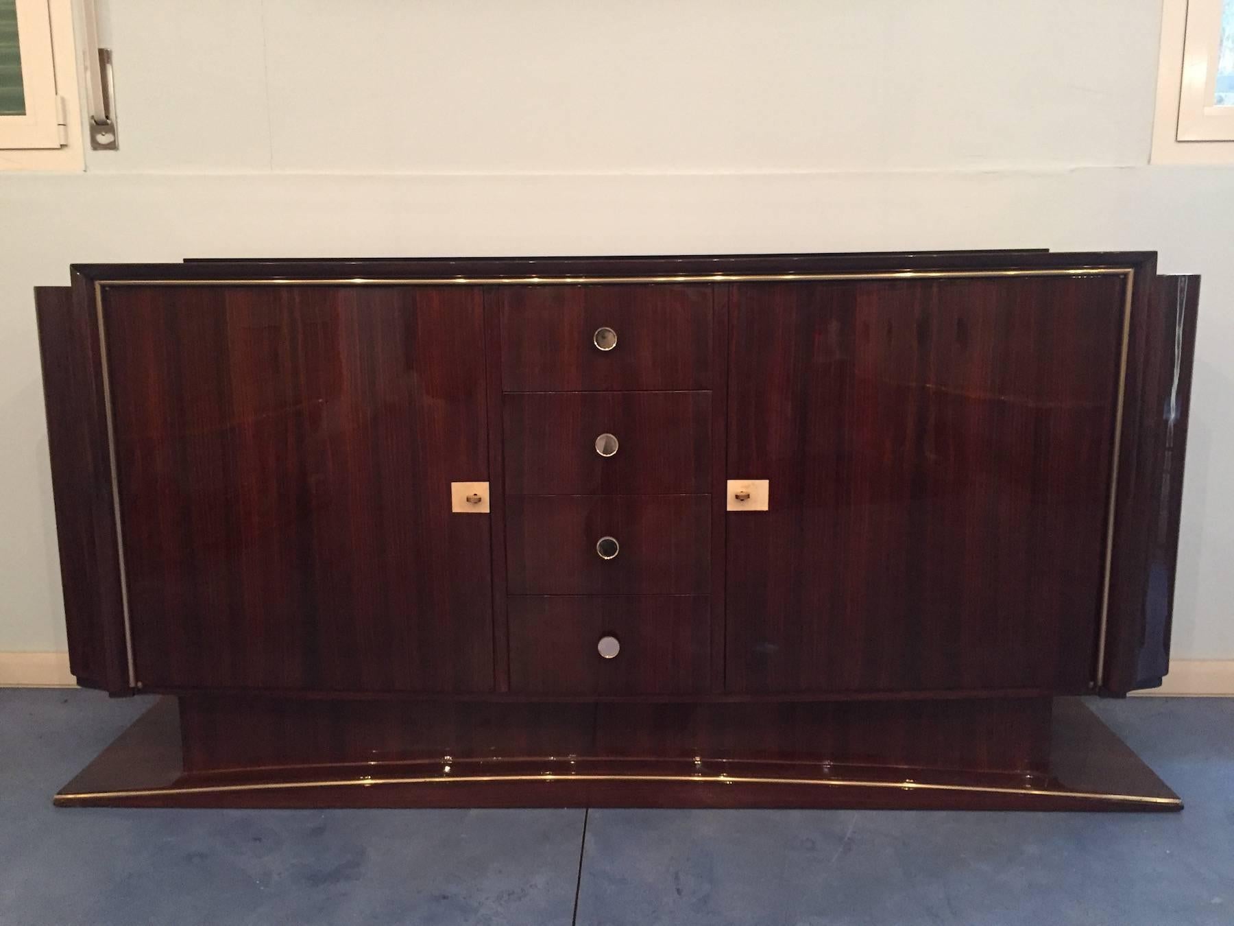 Elegant French Art Deco sideboard in rosewood, slightly arched lines on the front, top in opaline, splendid movement on the sides, “moustache” legs. Golden metal finishing, doors decorated in parchment, insides in maple.