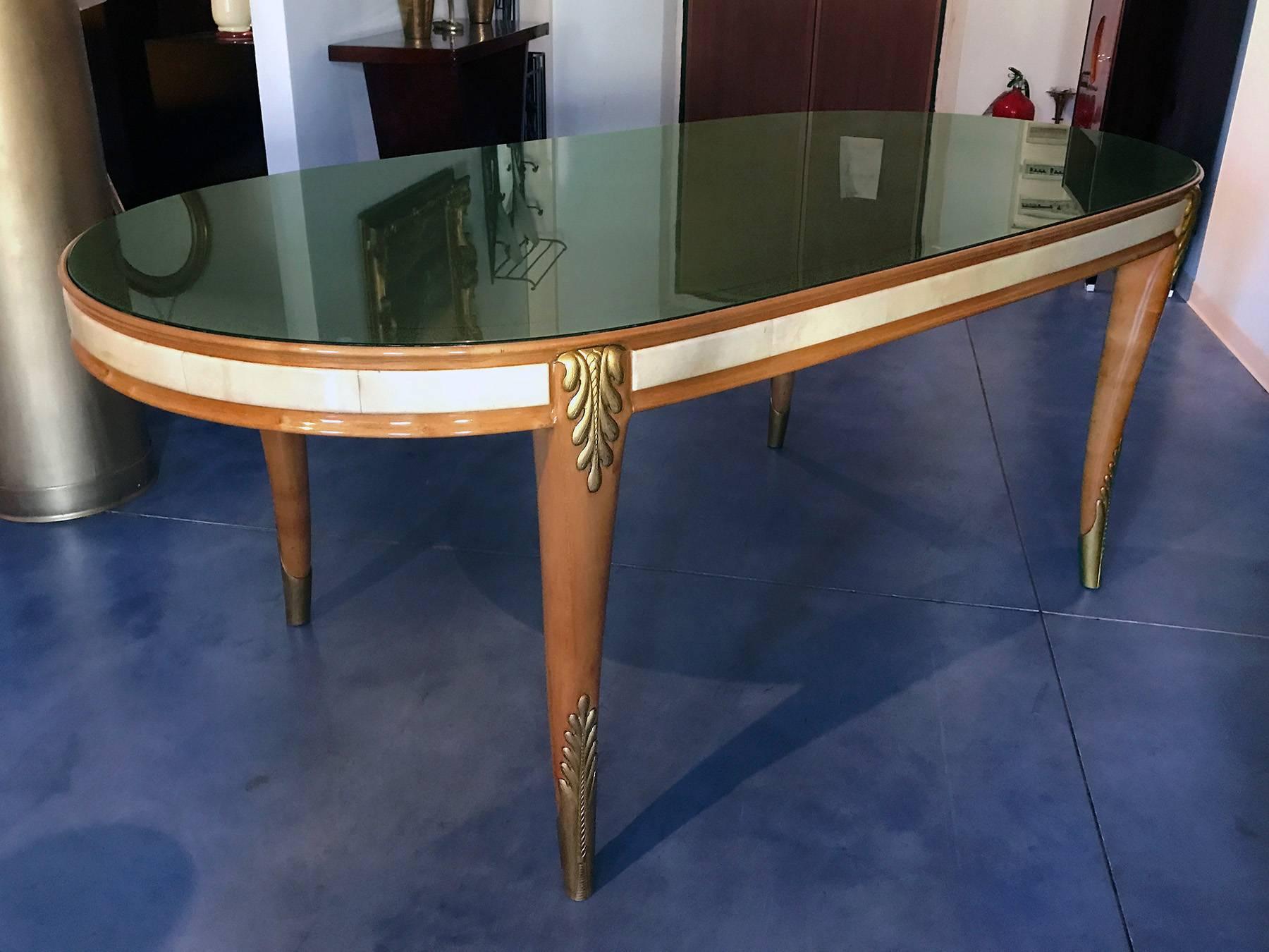 Very rare dining table designed by Giovanni Gariboldi in the late 1940s, possibly produced by Quarti.
The structure is in pearwood, finished with parchment and carved gilt-wood on the legs.
The glass tabletop is in sage green color, finely decorated