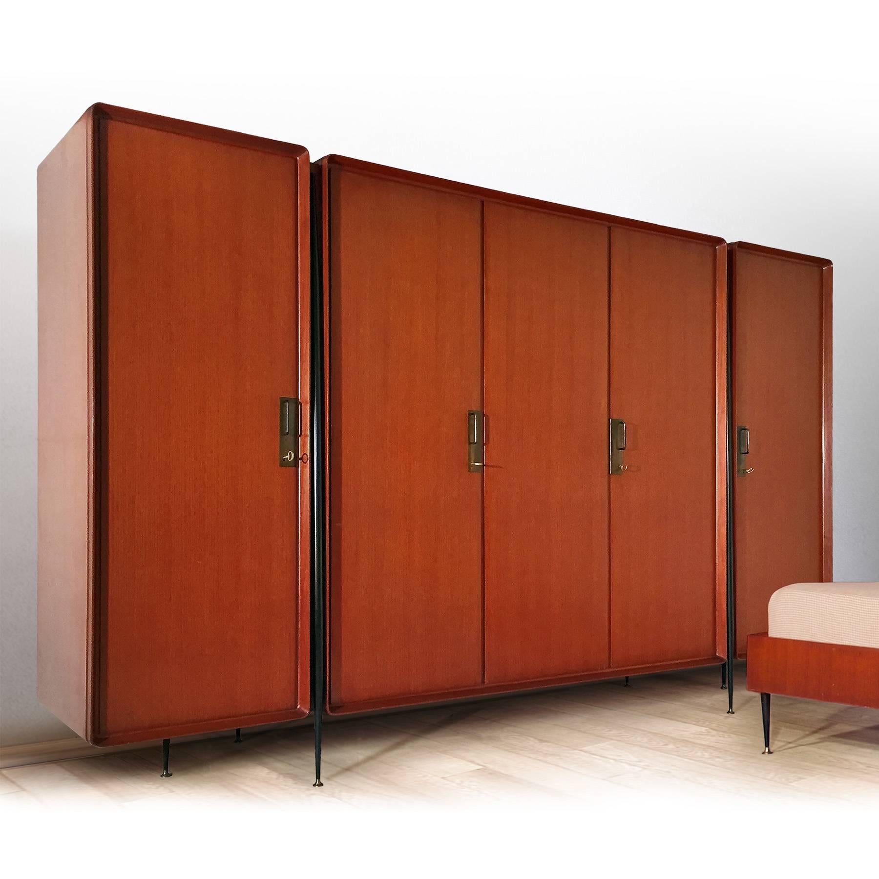 Stylish Italian wardrobe designed by Silvio Cavatorta in the 1950s.
The cabinet is made of semi gloss lacquered teak veneer with five doors finished with brass details, supported on tapered steel legs with brass feet.
Internally it offers a lot of