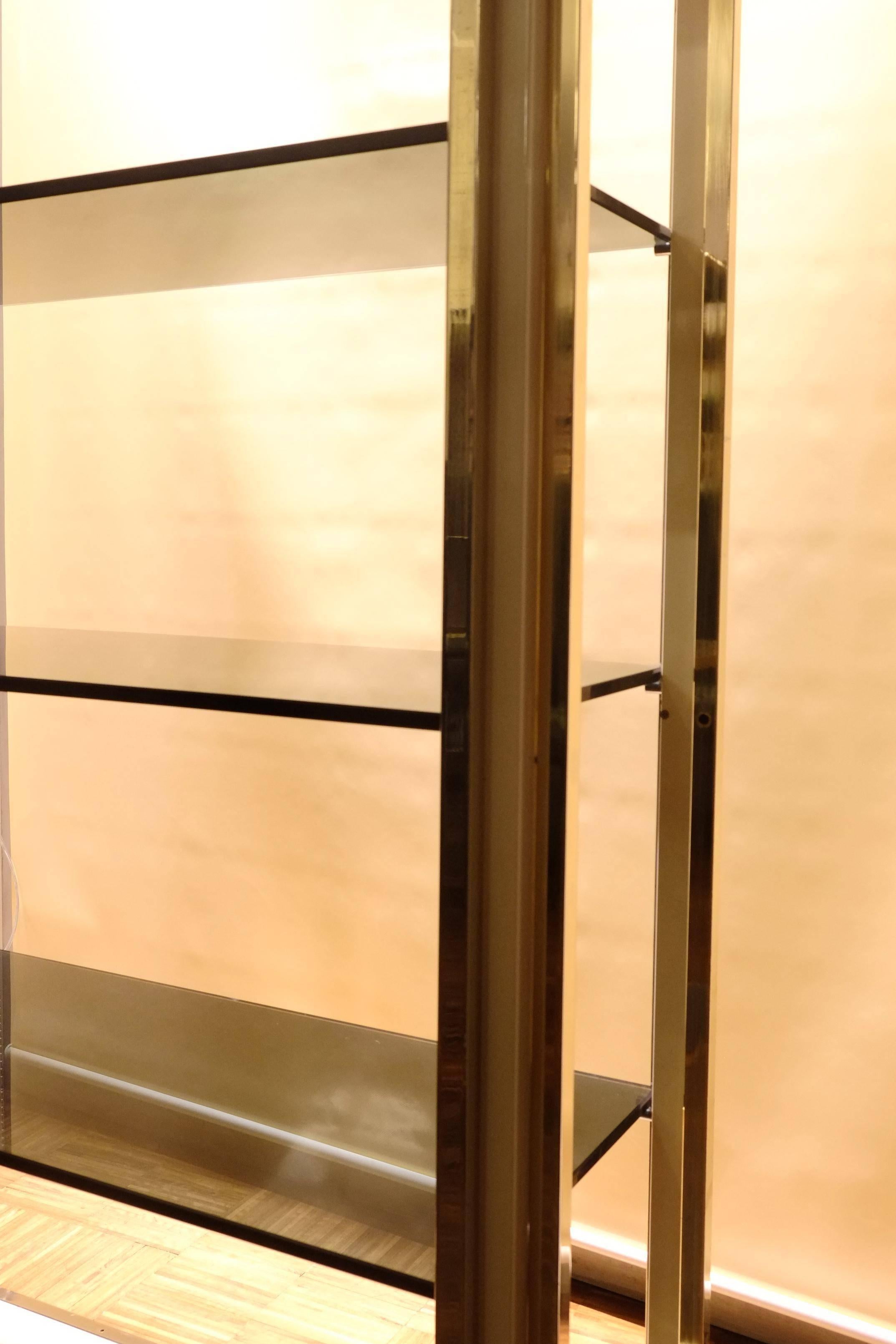 Pair of modern Italian brass and glass display cabinets or vitrines by Romeo Rega, from the 1960s. Painted metal bodies with brass trim and alternating brass and glass shelves.