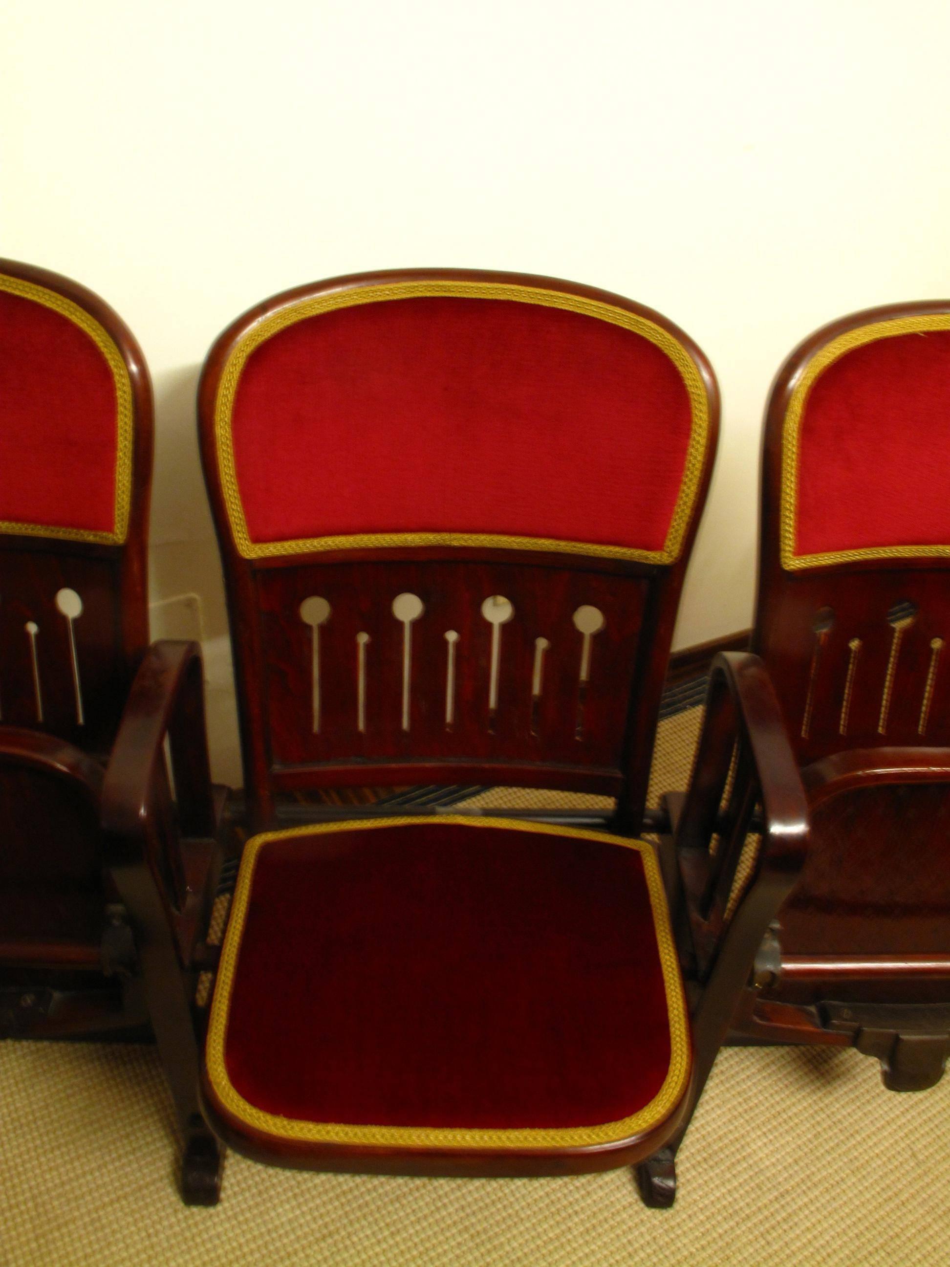 Original set of four connected bentwood theatre chairs by Thonet, circa 1907. Each chair folds up and down, has velvet-covered padding to the seat and back, as well as decorative piercing to seat lower back.