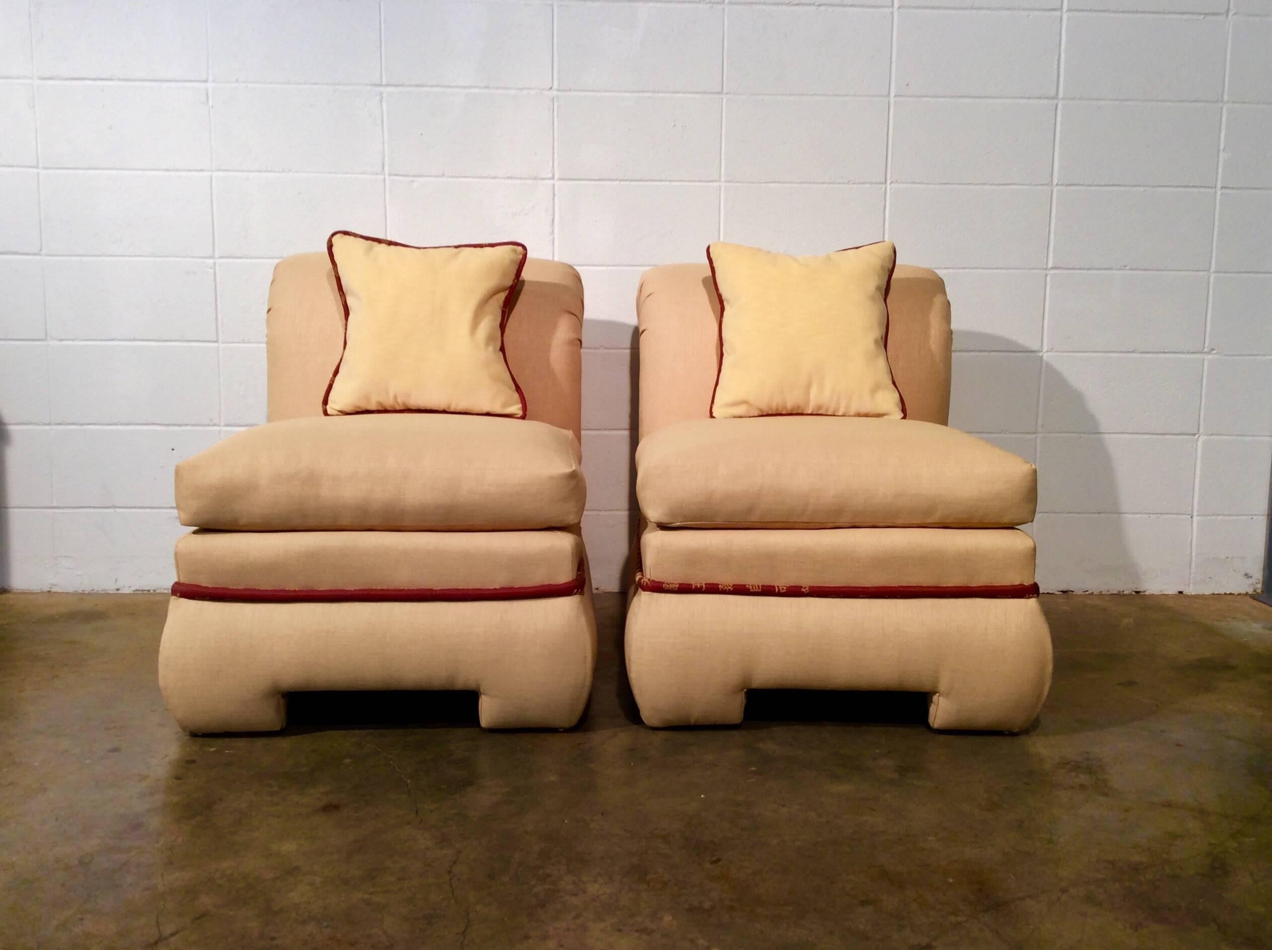 Pair of fully upholstered rolled back slipper chairs by Vanguard Furniture. Chairs seem to have been reupholstered recently. Light yellow fabric with a thick band of welting featuring Chinese font. Pillows are included.
No known issues that would