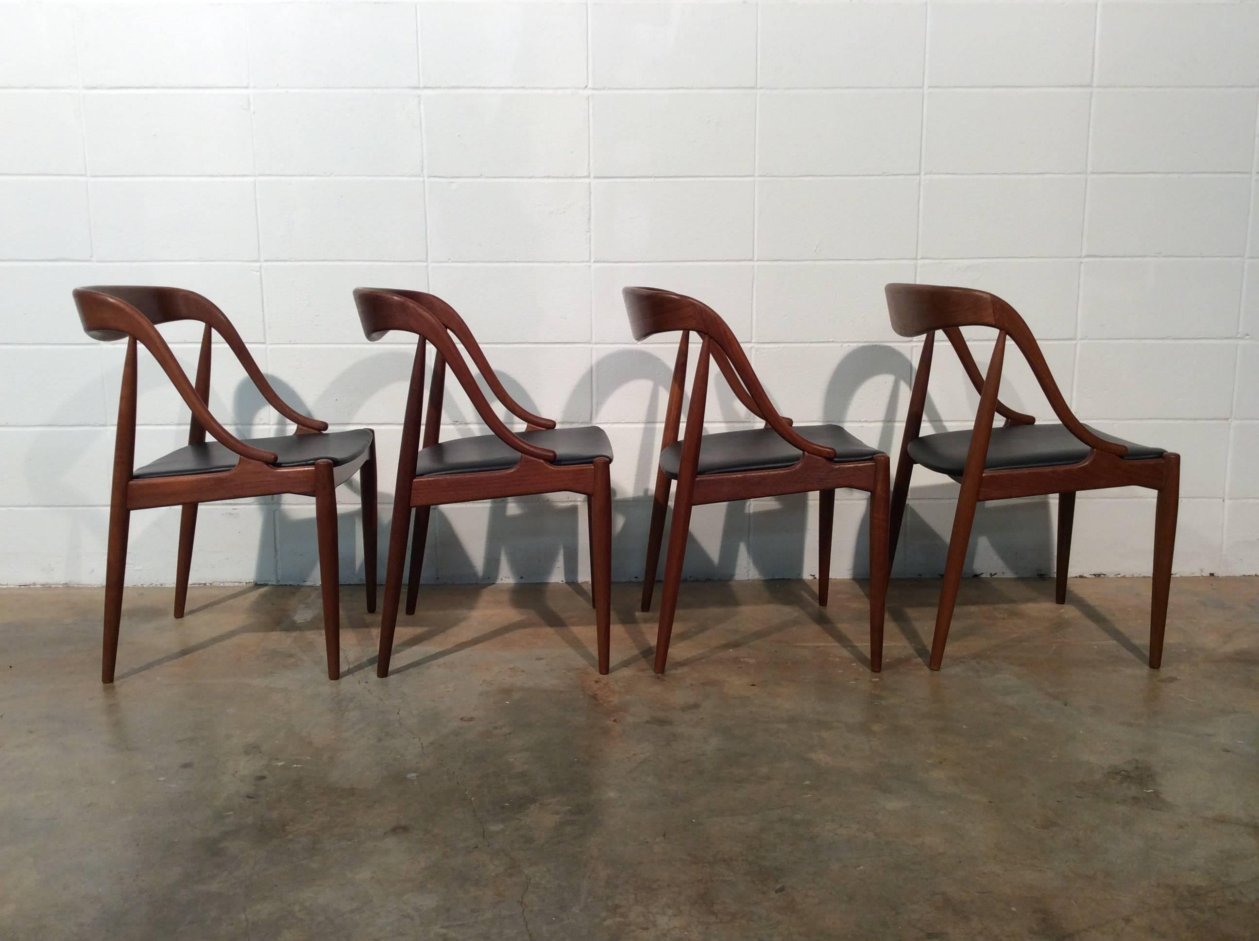 Set of four teak dining chairs designed by Johannes Andersen for / imported by Moreddi. The chairs have been thoroughly cleaned and oiled and are ready for use. They retain their original black vinyl, which is in great condition, as well as the