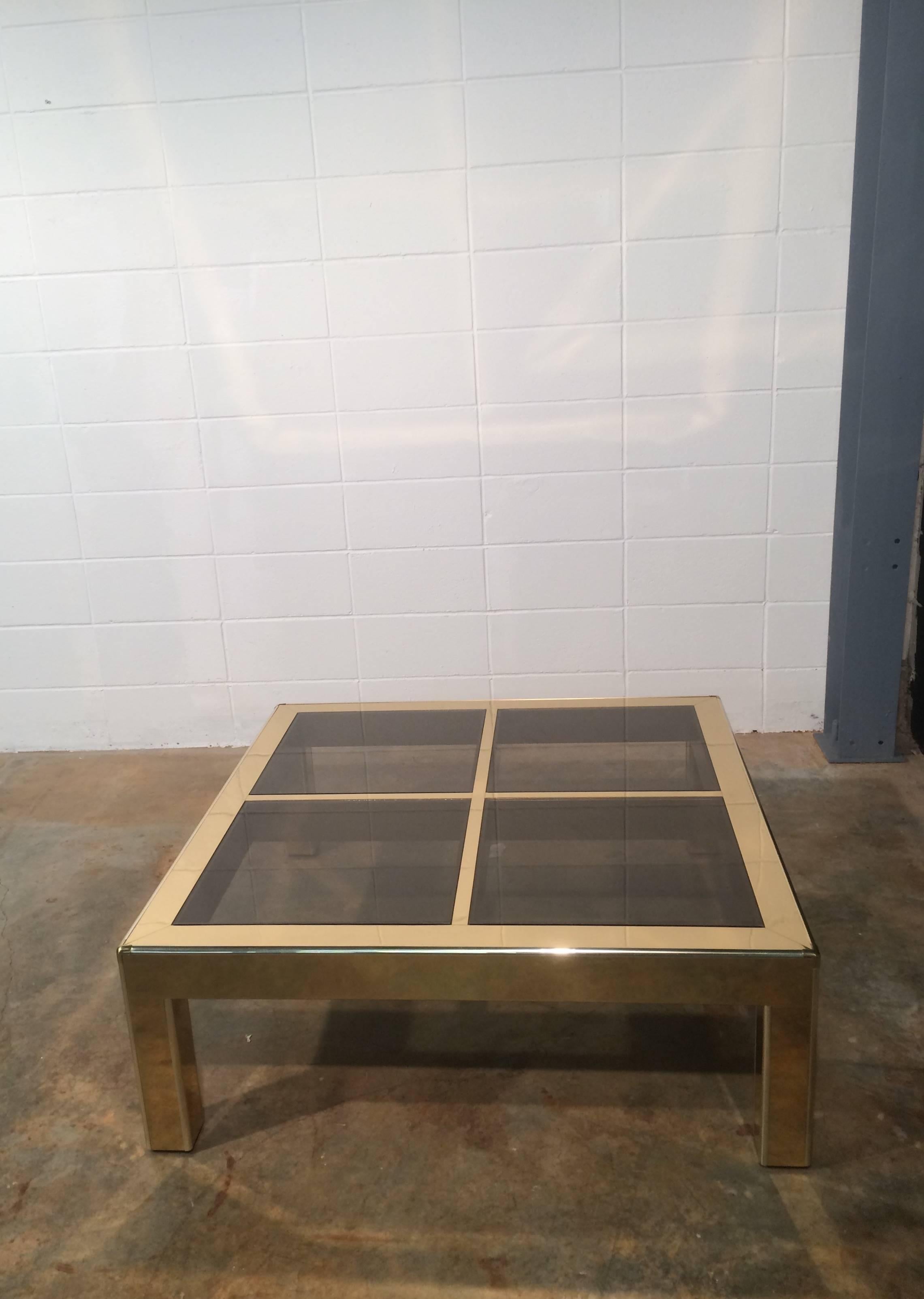 Sleek brass coffee table with tinted glass inserts by Mastercraft. Table is in great condition with very minimal wear. All of the glass is new and scratch free. Retains the Mastercraft label. 42