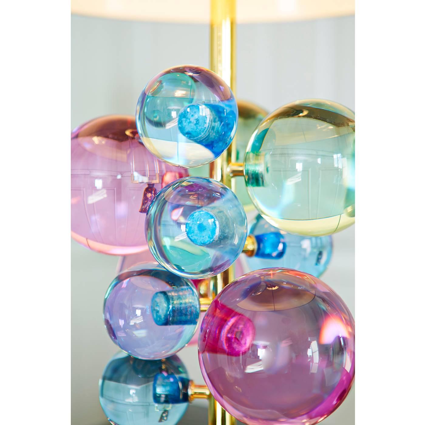 Lustrous sculpture. A constellation of Lucite spheres floats on a slim brass stem anchored by a sculptural marble base and topped with a brass dome. The shade refracts the light, makes the orbs sparkle, and creates a warm glow. Available in
