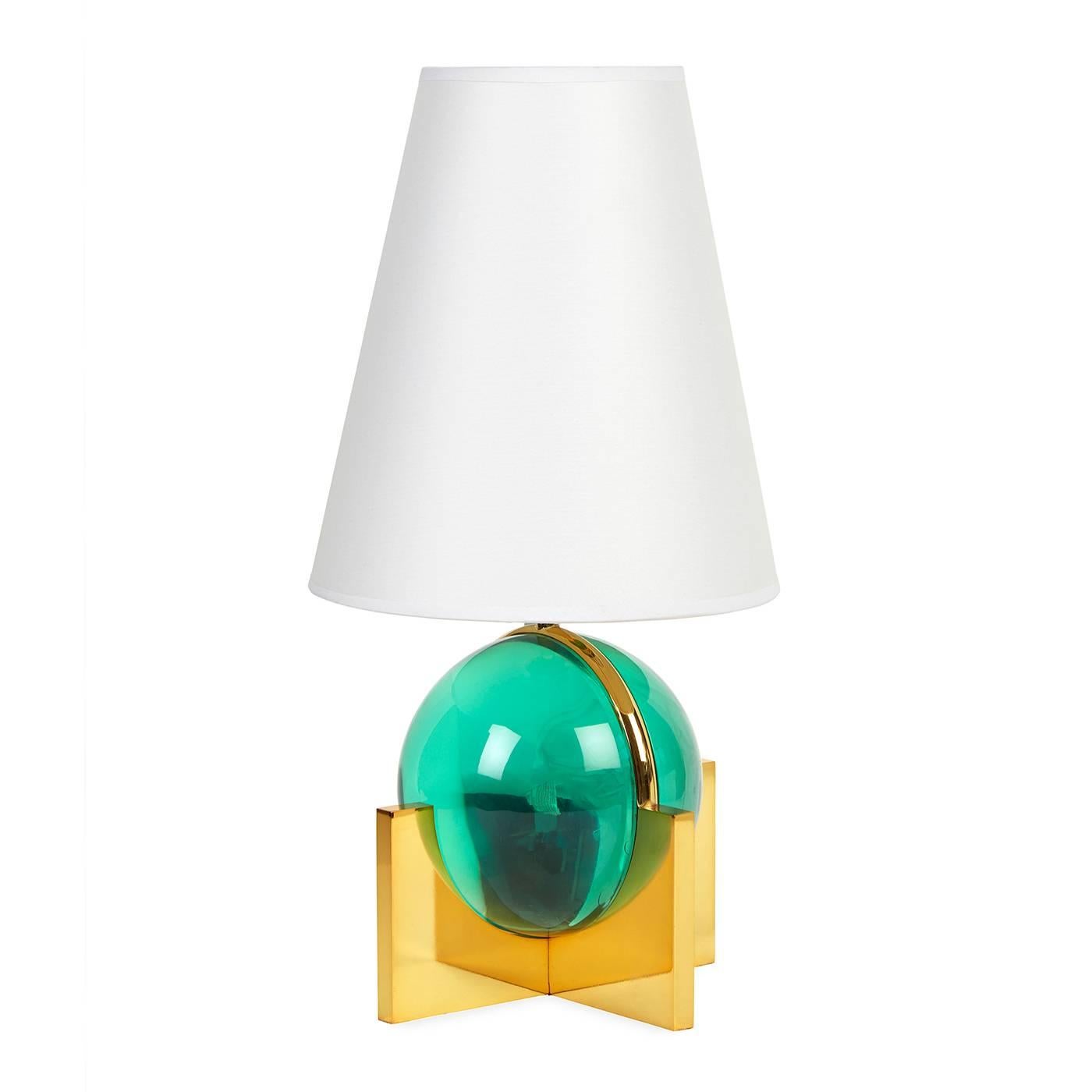 Futuristic elegance. A Minimalist crossed base of solid brass supports a luminous globe of Lucite in this diminutive nod to Machine Age Modernism. Inspired by the settings of a cocktail ring, the globo vanity lamp is jewelry for your home. Perfect