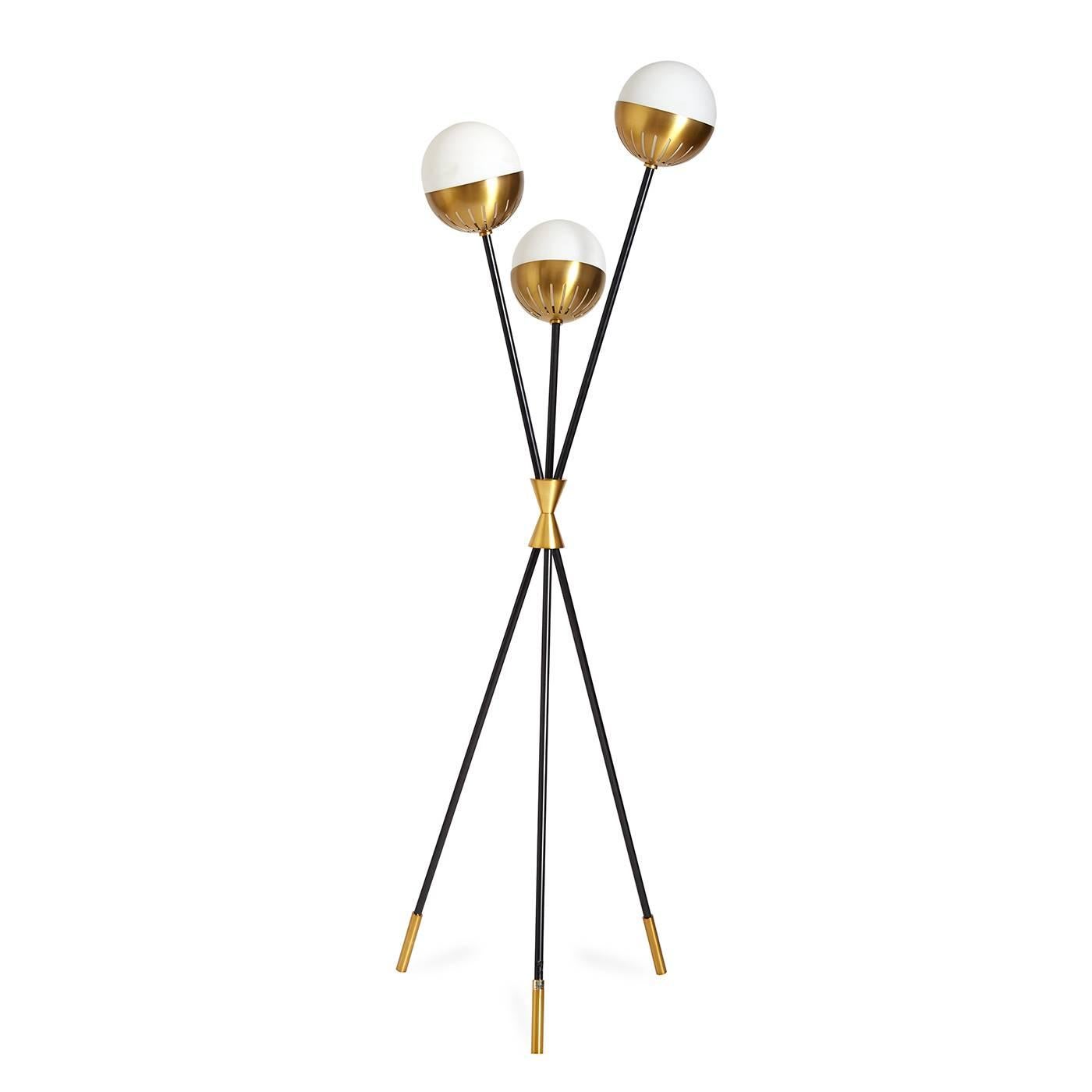 Kinetic modernism. Divinely dynamic, the Caracas tripod floor lamp is light and airy—but with a strong presence. Blackened metal stems of differing heights are gathered with a bowtie cuff in antique brass. Each stem supports a softly glowing milk