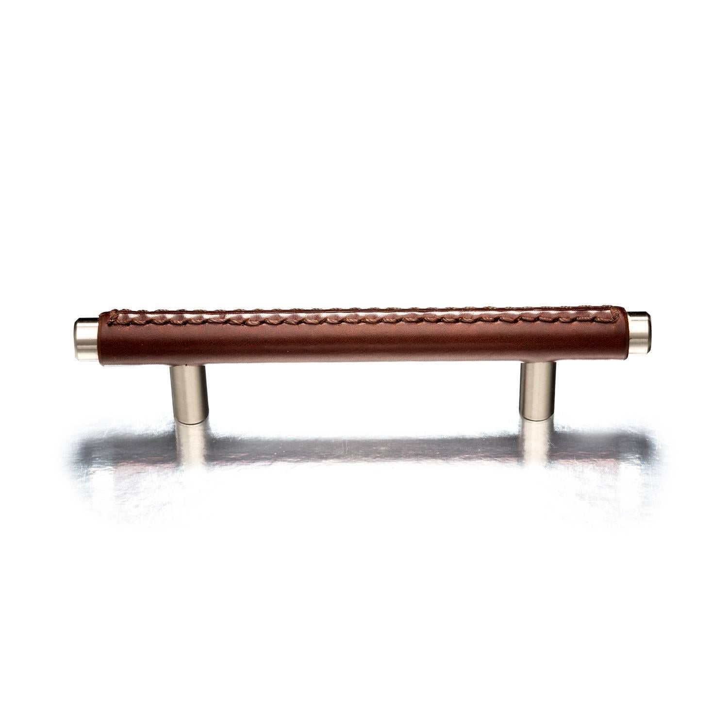 Hand-stitched leather T-bar cabinet pull, featuring traditional saddle stitch. Available in various metal finishes and sizes.