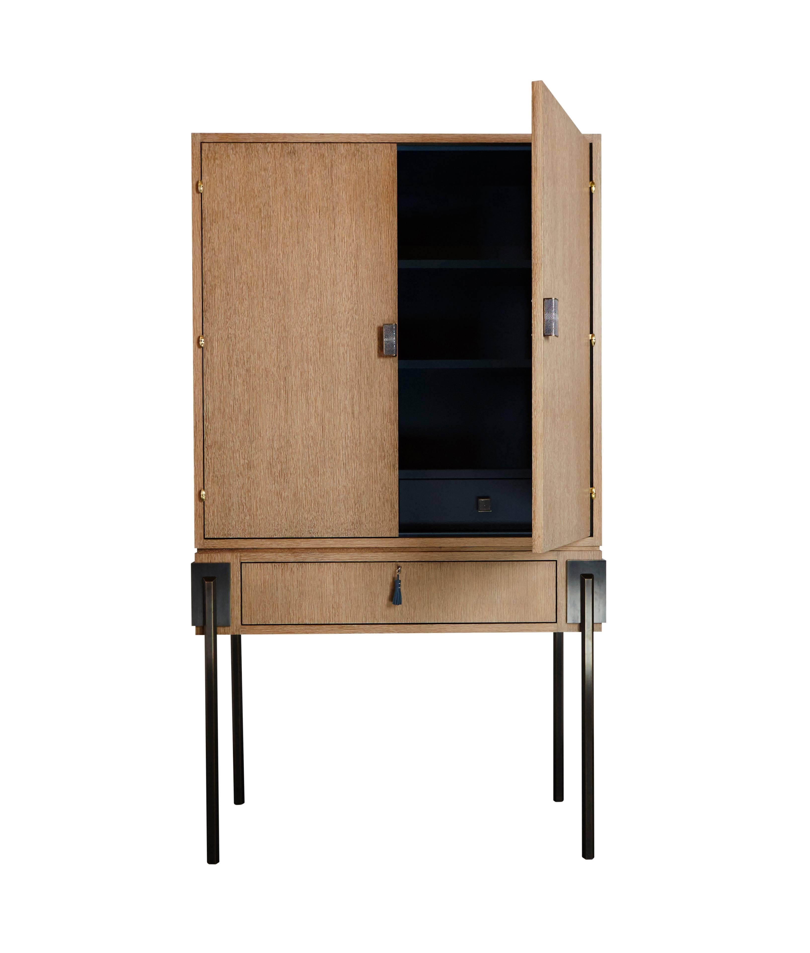 The HEX Armoire is a cerused white oak cabinet that blends the purity of wood with a surprising blue leather interior. The piece is accented by eloquent details like monolithic bronze legs, blue leather tassels, and original sculpted CZA ‘Waterfall’