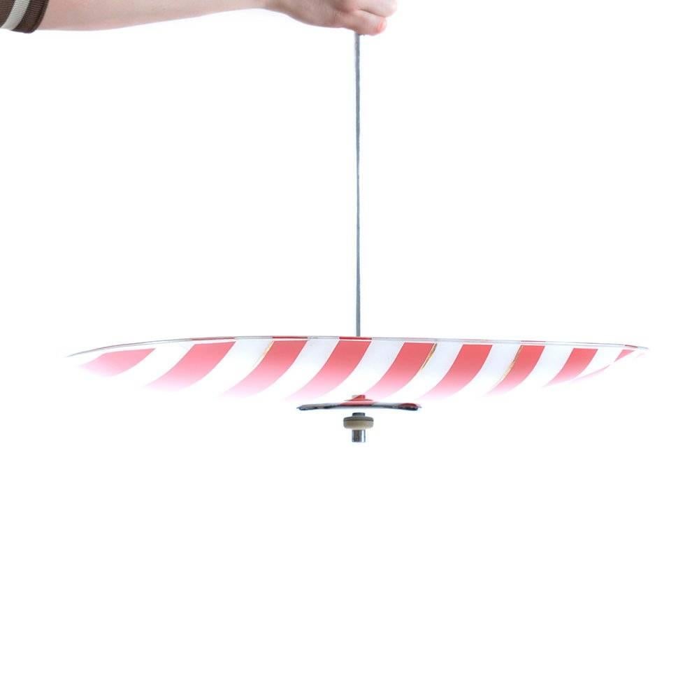 Glass ceiling light produced by Napako company in Czechoslovakia. Plate lights were very popular in Czechoslovakia in the Mid-Century era. The glass plate on this light is in red and white stripe combination. Construction and stick is of chrome