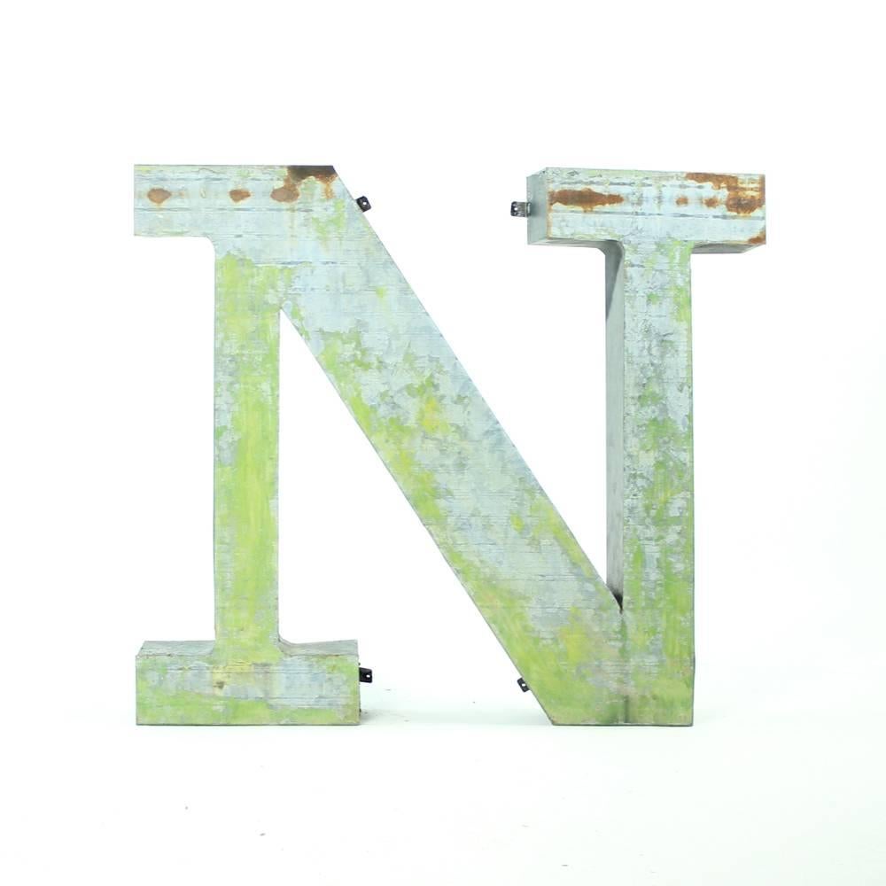 This large metal letter N was originally used as a part of the name sign in a factory in Czechoslovakia. It is made fully of shaped metal sheet. It is empty from the back and so it is light to hang on a wall thanks to the hanging fixtures which are