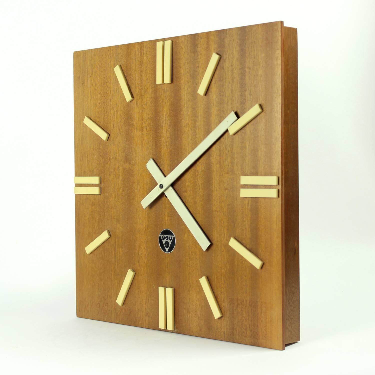 This beautiful large wooden wall clock looks amazing on a wall. Created as a interior edition of Pragotron clock, ment for public places like restaurants or offices in Czechoslovakia in 1980s. Square clock is made of plywood with mahagony veneer.