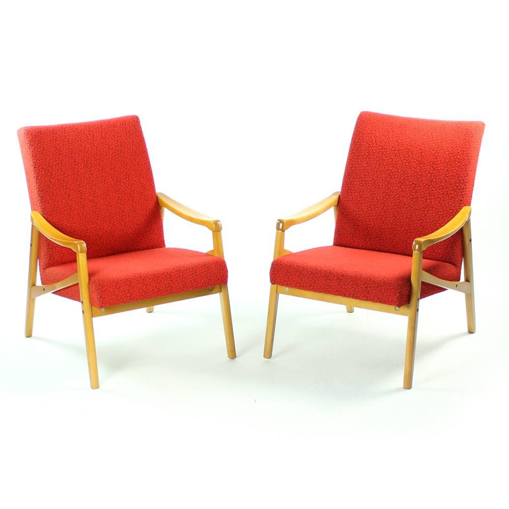 These two beautiful armchairs show the typical Mid-Century armchair design by Interier Praha. They were created in 1971 in Czechoslovakia. Upholstered in original red fabric which shows only minor wear. The lighter wood in very good condition and