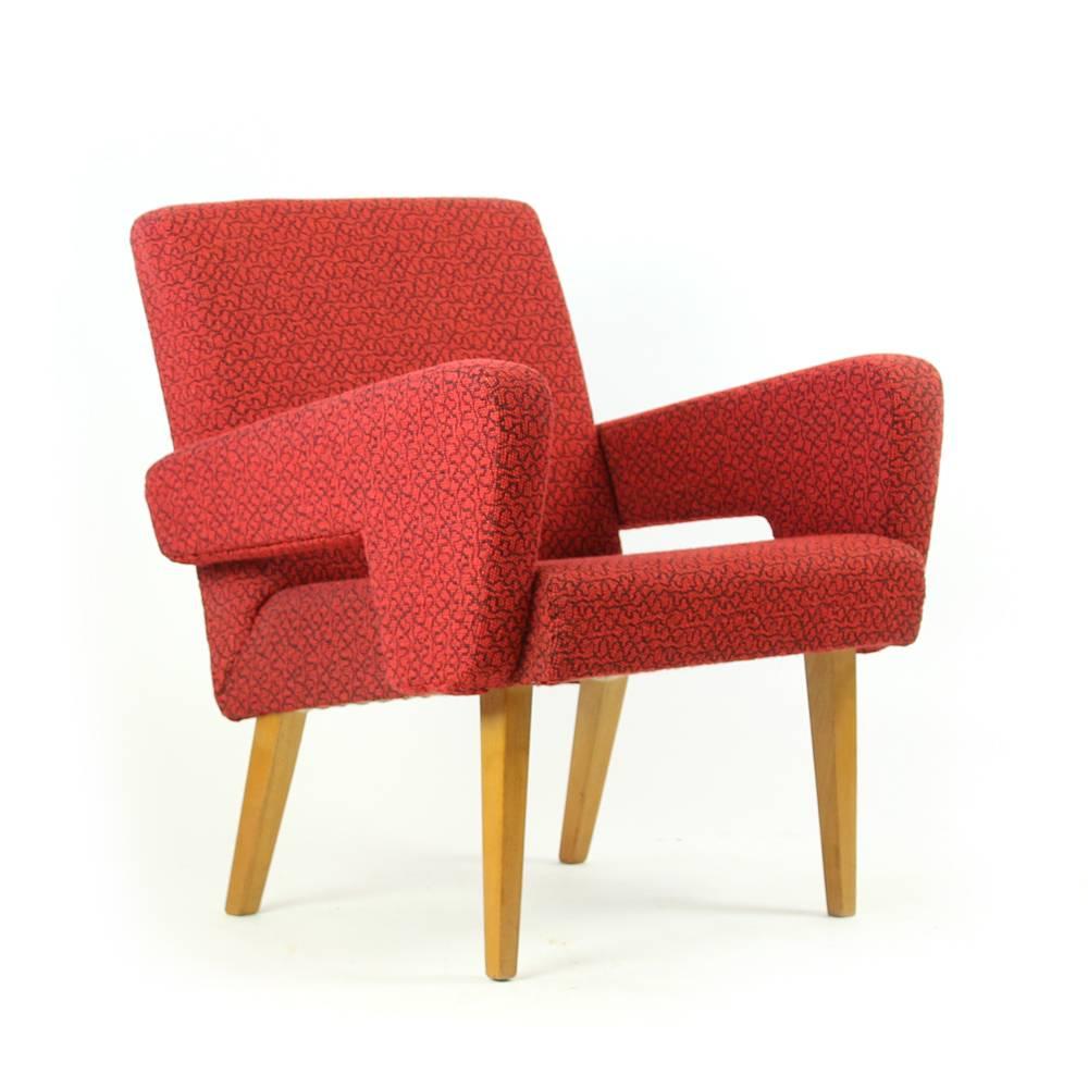 This armchair defines Mid-century design and design classics by Jitona. The beautiful red armchair is combined with four wooden legs which only add to 1960s era. The chair is in original red upholstery. It is in a very good condition with only minor