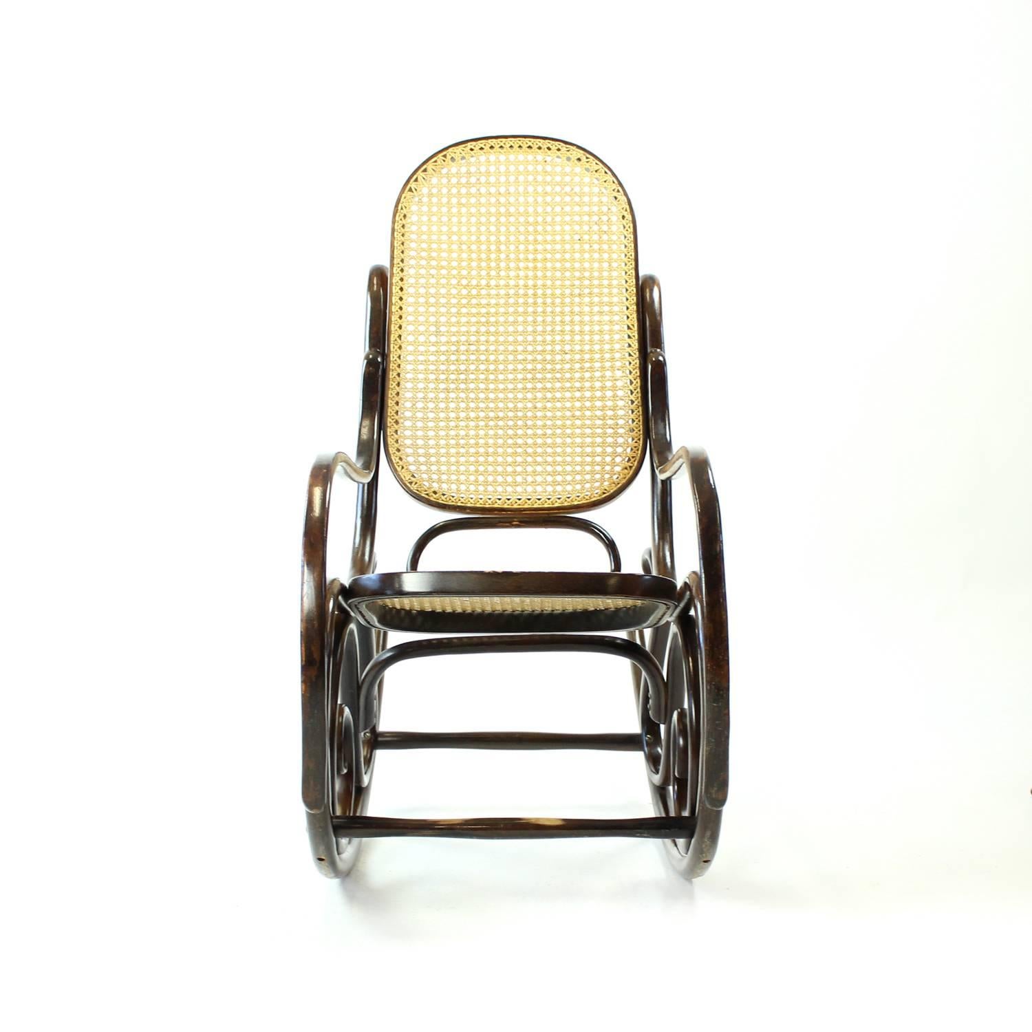 Beautiful rocking chairs in Thonet style, made of dark bentwood. Most beautiful construction with lots of details. Original weaving in very good condition with some minor wear and signs of use. Some patina visible on the armrests, too. But it makes