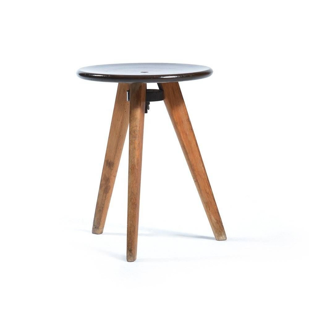 Industrial looking tripod stool from the midcentury era of 1960s from Czechoslovakia. Made of three wooden legs and Bakelite seat. Screw in mechanism allows you to adjust the seat a little bit and make it really strong and stabile. Not to mention it