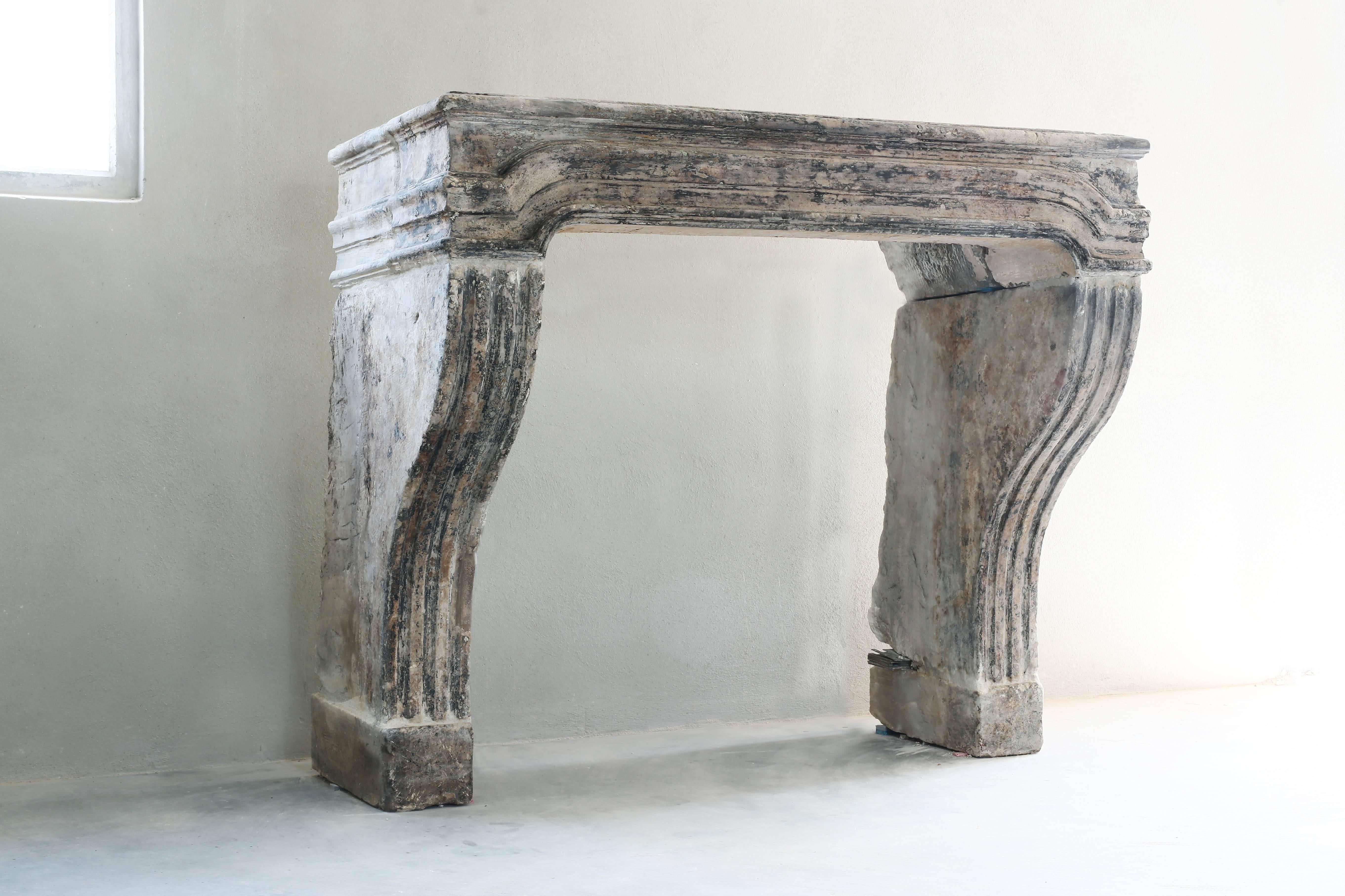 Chique antique fireplace of limestone with nice ornaments. From the 18th century in the style of Louis XIV.