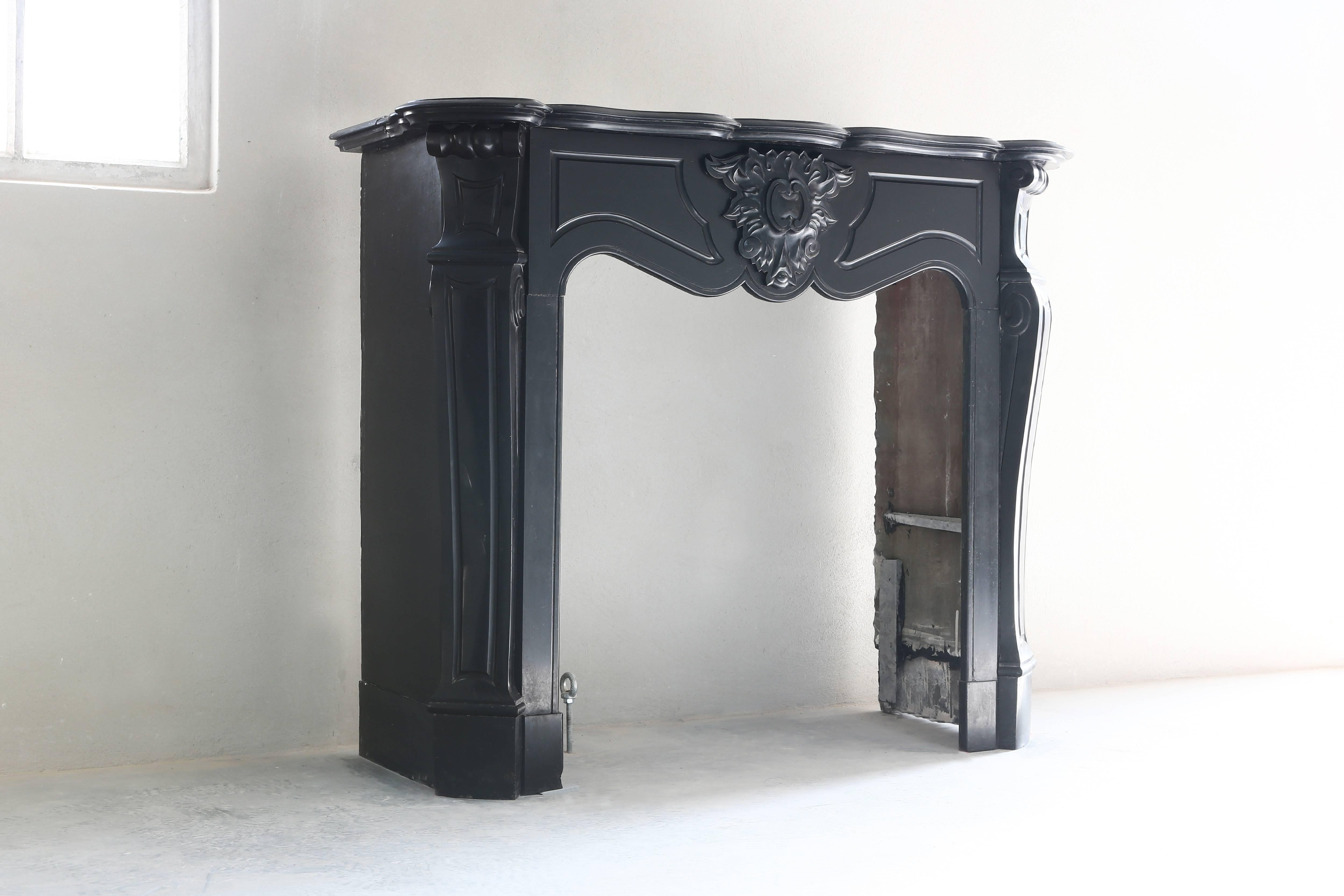 A very nice and antique marble fireplace from Belgium! The kind of marble is called 'Noir de Mazy' and is a very special one that is characterized by the deep black color! This antique fireplace is from the century of Louis XV.
