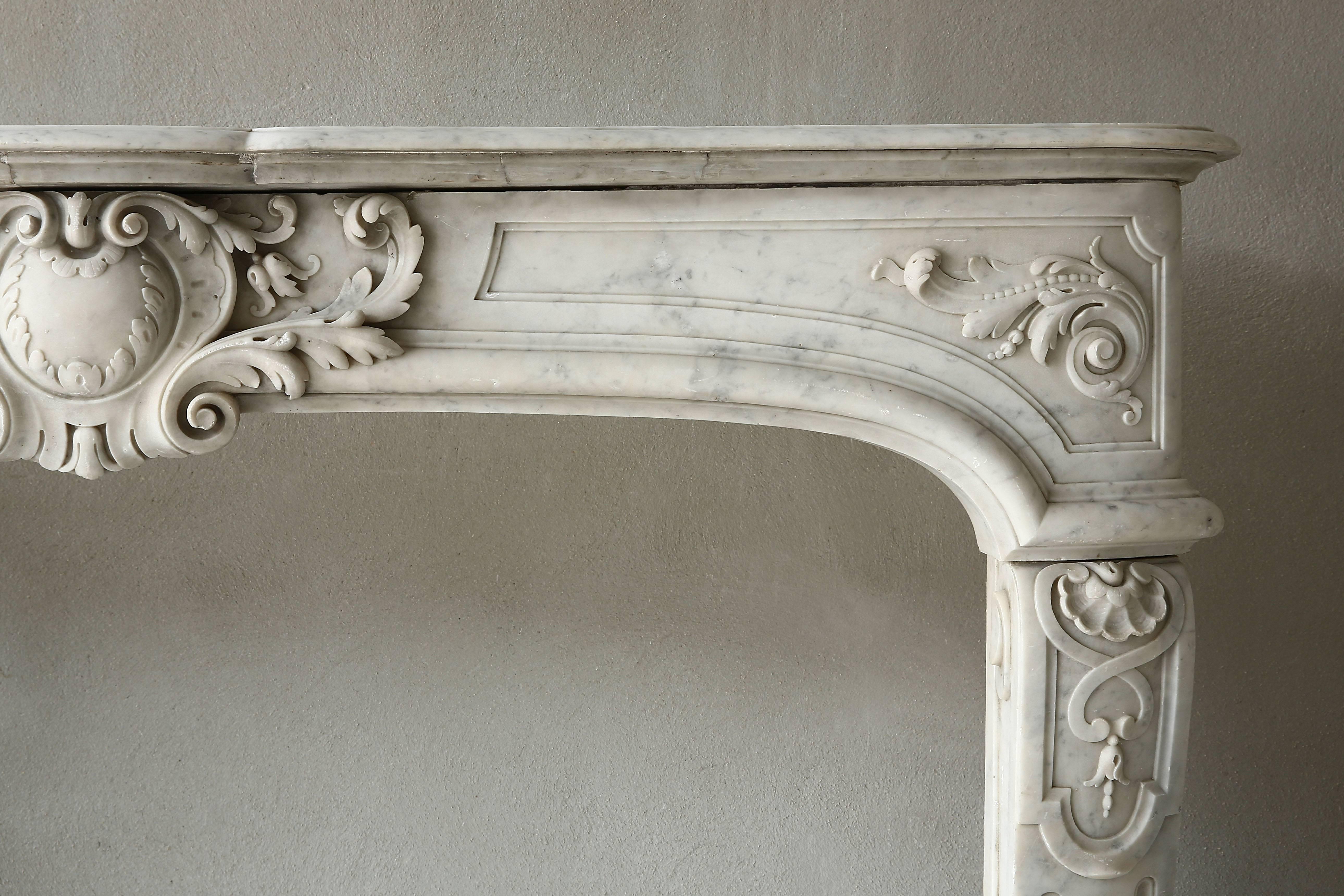 Very rare marble antique fireplace from the era of Louis XIV of white Carrara marble. This unique fireplace dates back to the 19th century. The curved legs are decorated with scallops and cannellures. The front part has a beautiful scallop in the