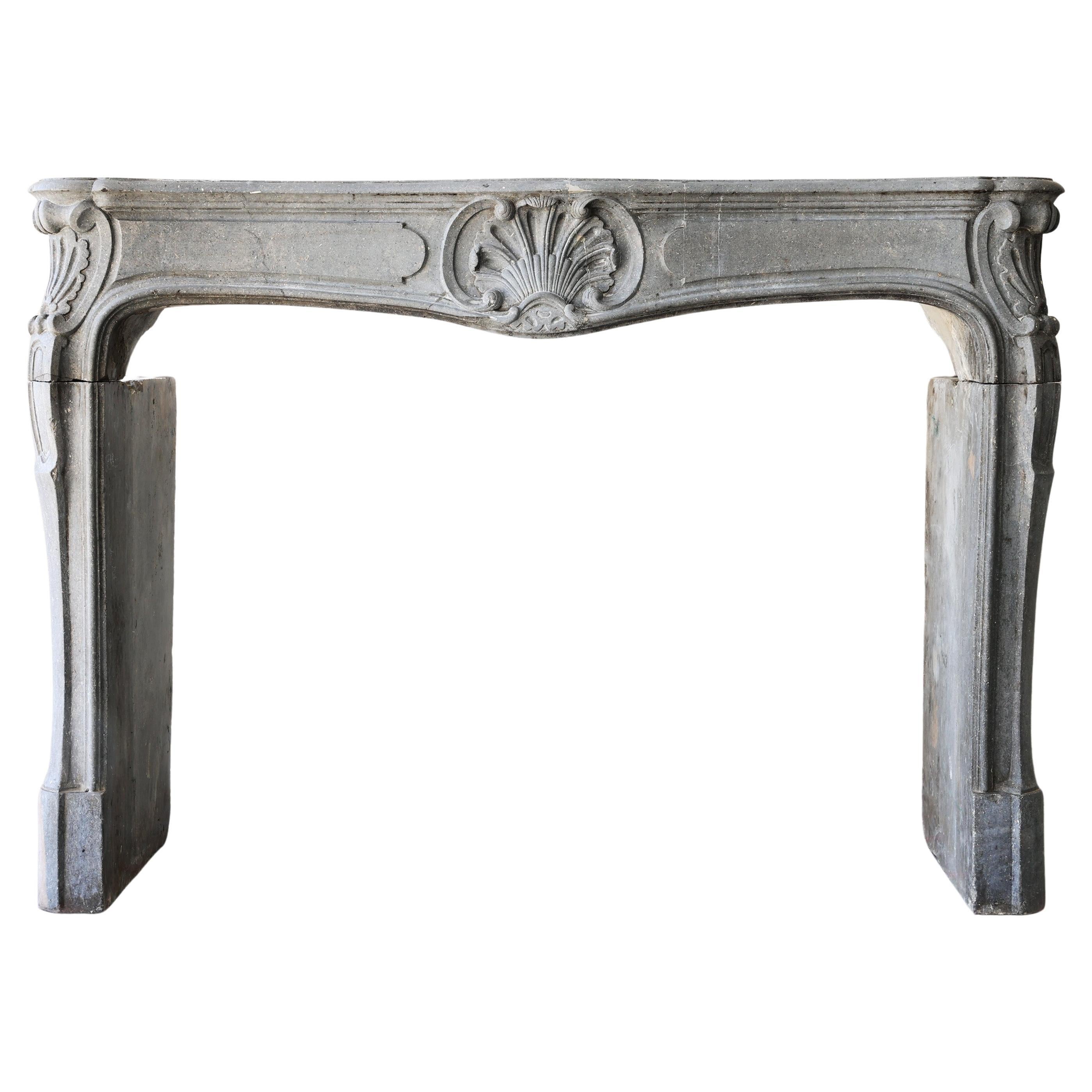 Antique fireplace of grey marble stone from the 19th century, style of Louis XV