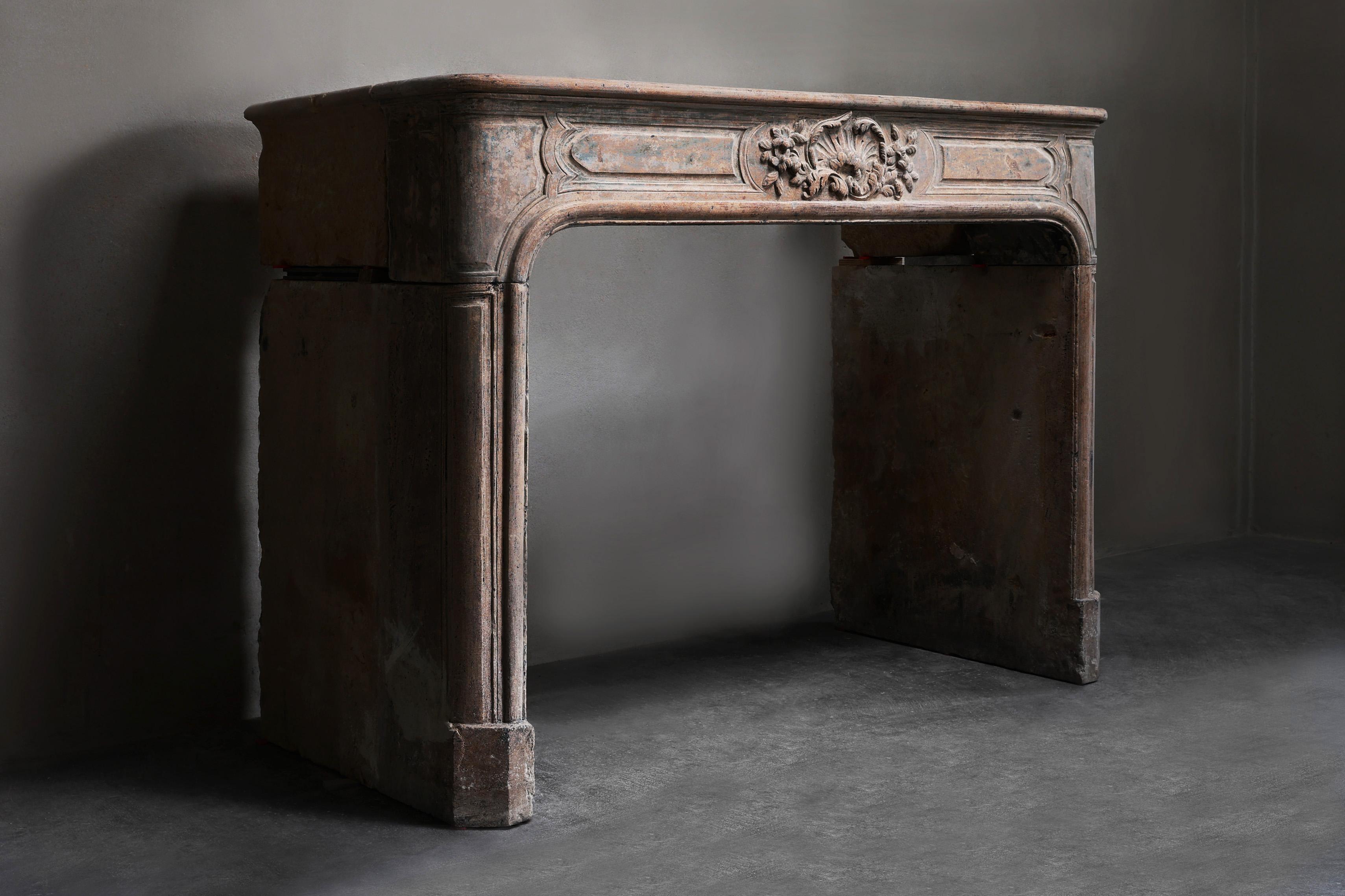 This authentic 19th century mantelpiece is made of French limestone in the elegant Louis XVI style. With refined floral motifs and classic lines, this antique fireplace is a timeless piece of furniture. Perfect for those looking for a stylish,
