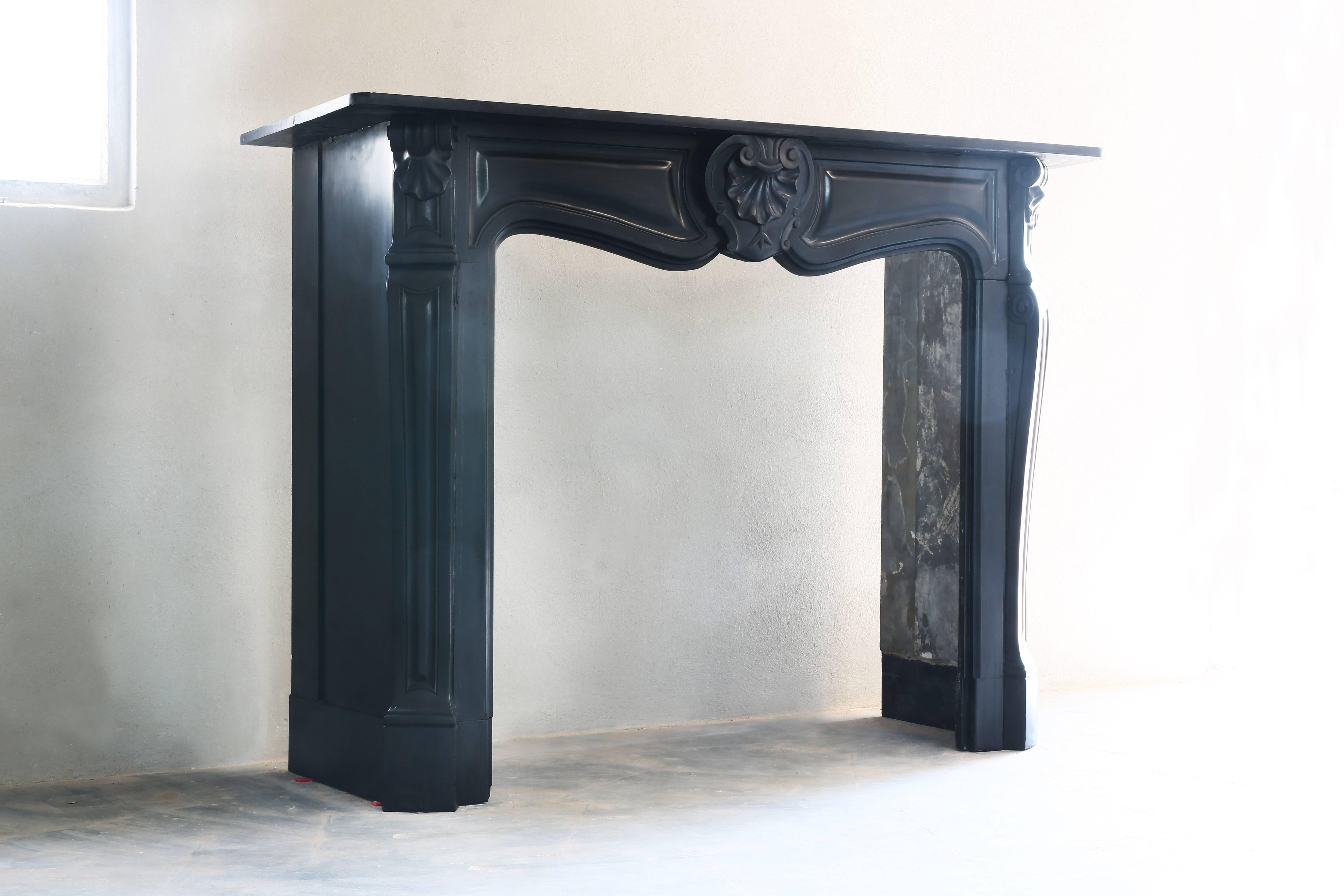 A very nice black antique fireplace of 'Noir de Mazy' marble. We found this one in Belgium and is from the century of Louis XV.