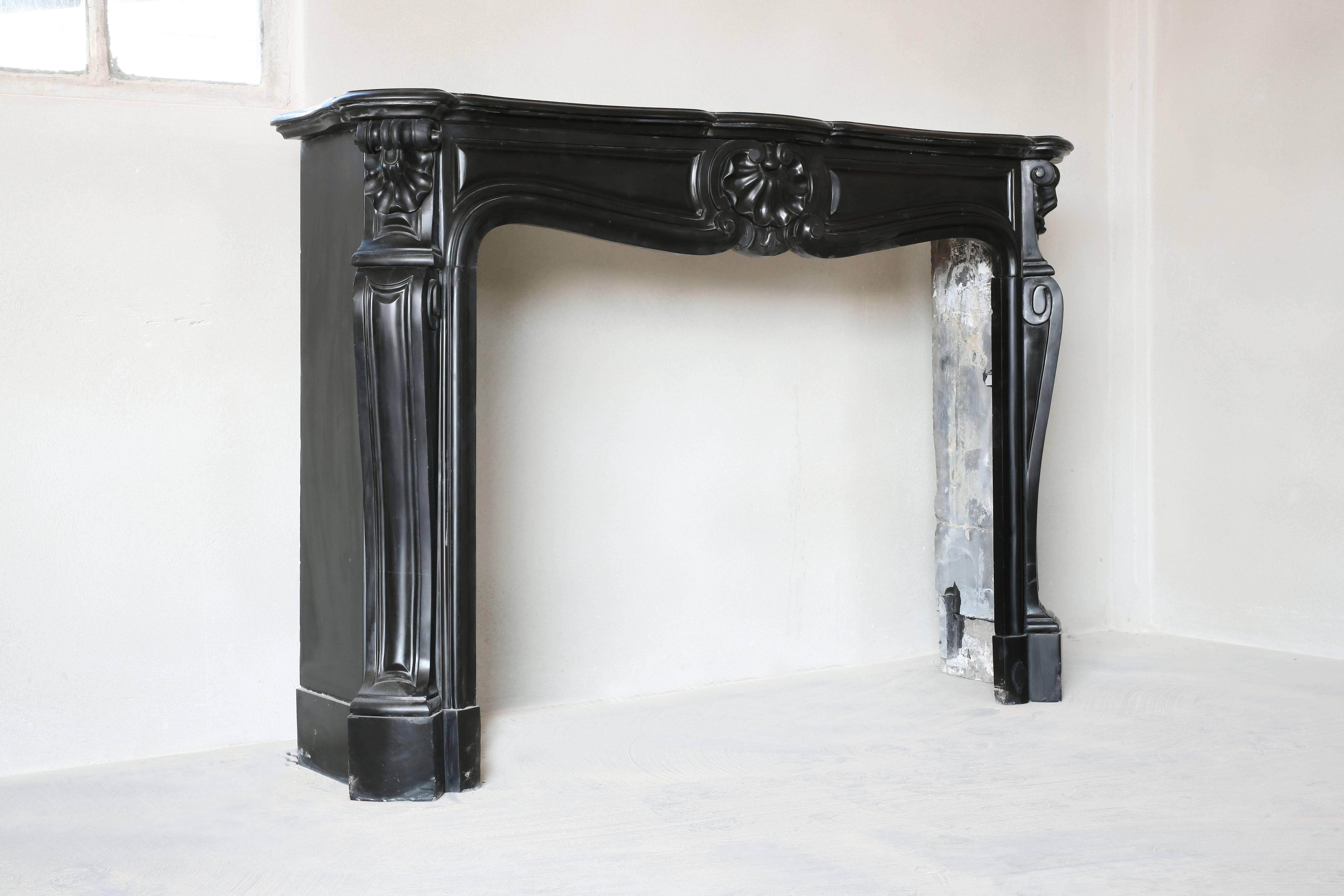 Antique Noir de Mazy fireplace from Belgium. Very nice with the coquille in the middle of the front and on both sides of the legs.