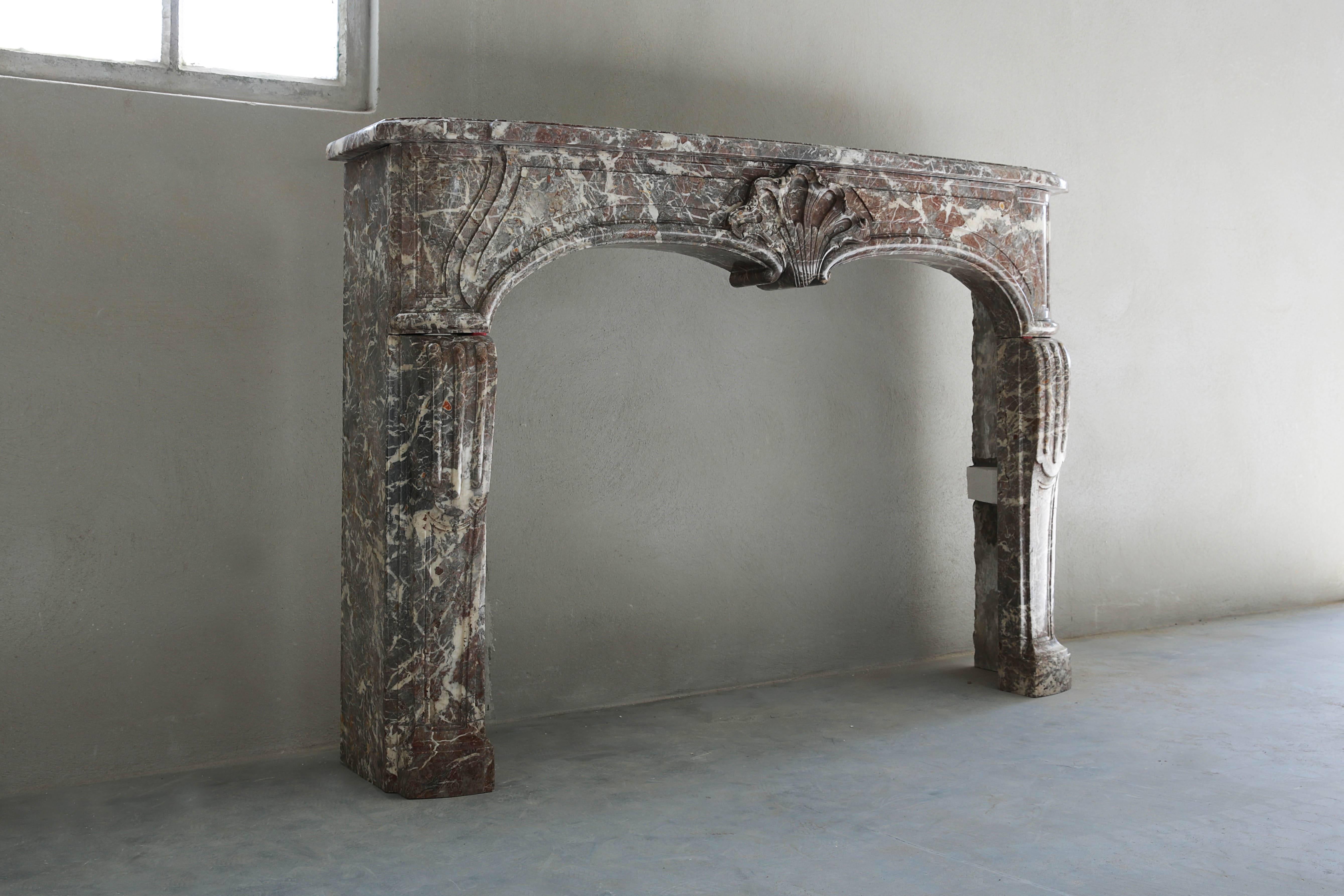 A unique and marvellous antique fireplace of Rouge Royal marble from Belgium. The fireplace is in the style of Louis XV.