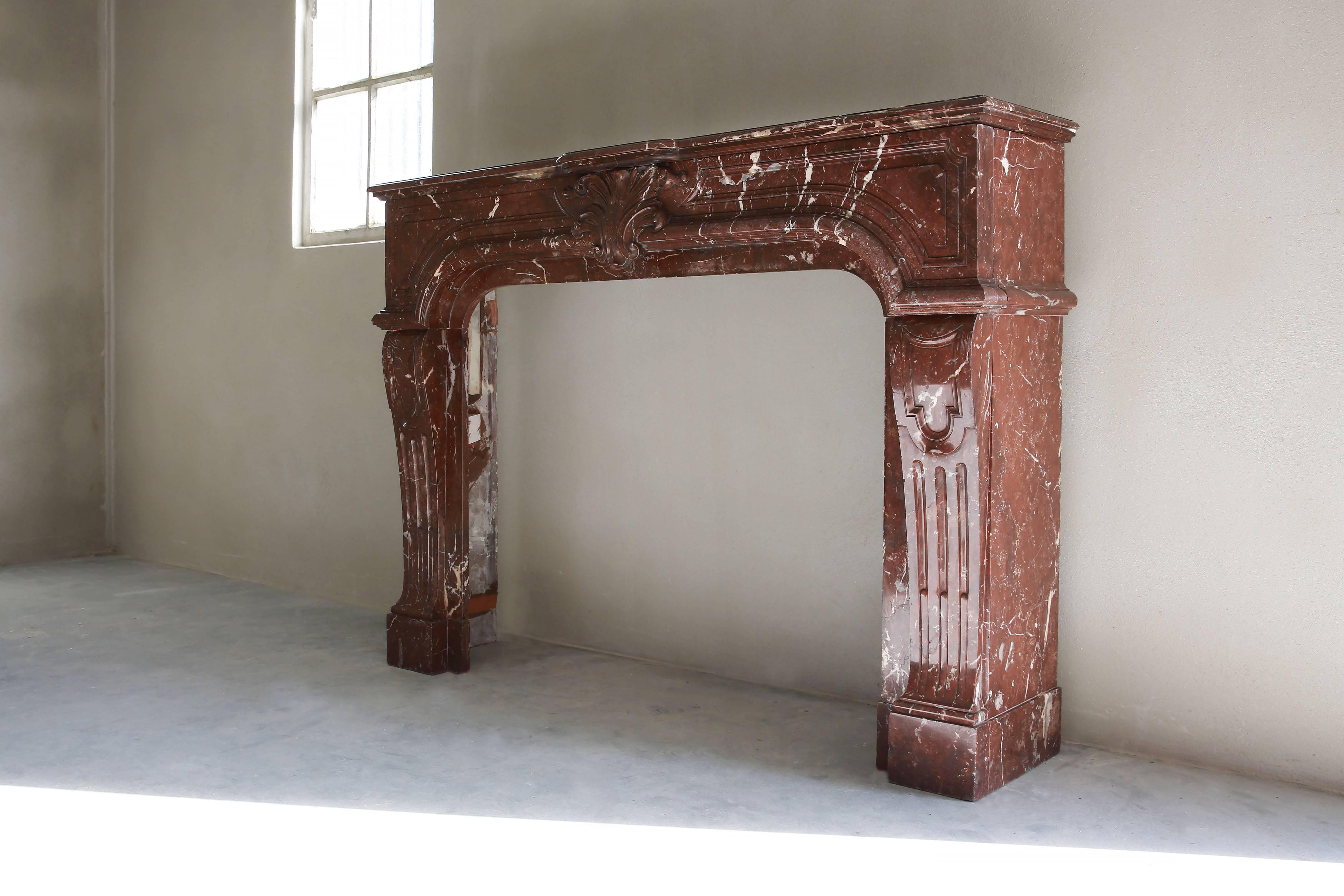 A very special and exclusive antique marble fireplace of Griotte Rouge from Belgique. This fireplace has a very warm and excellent appearance in the style of Louis XIV.