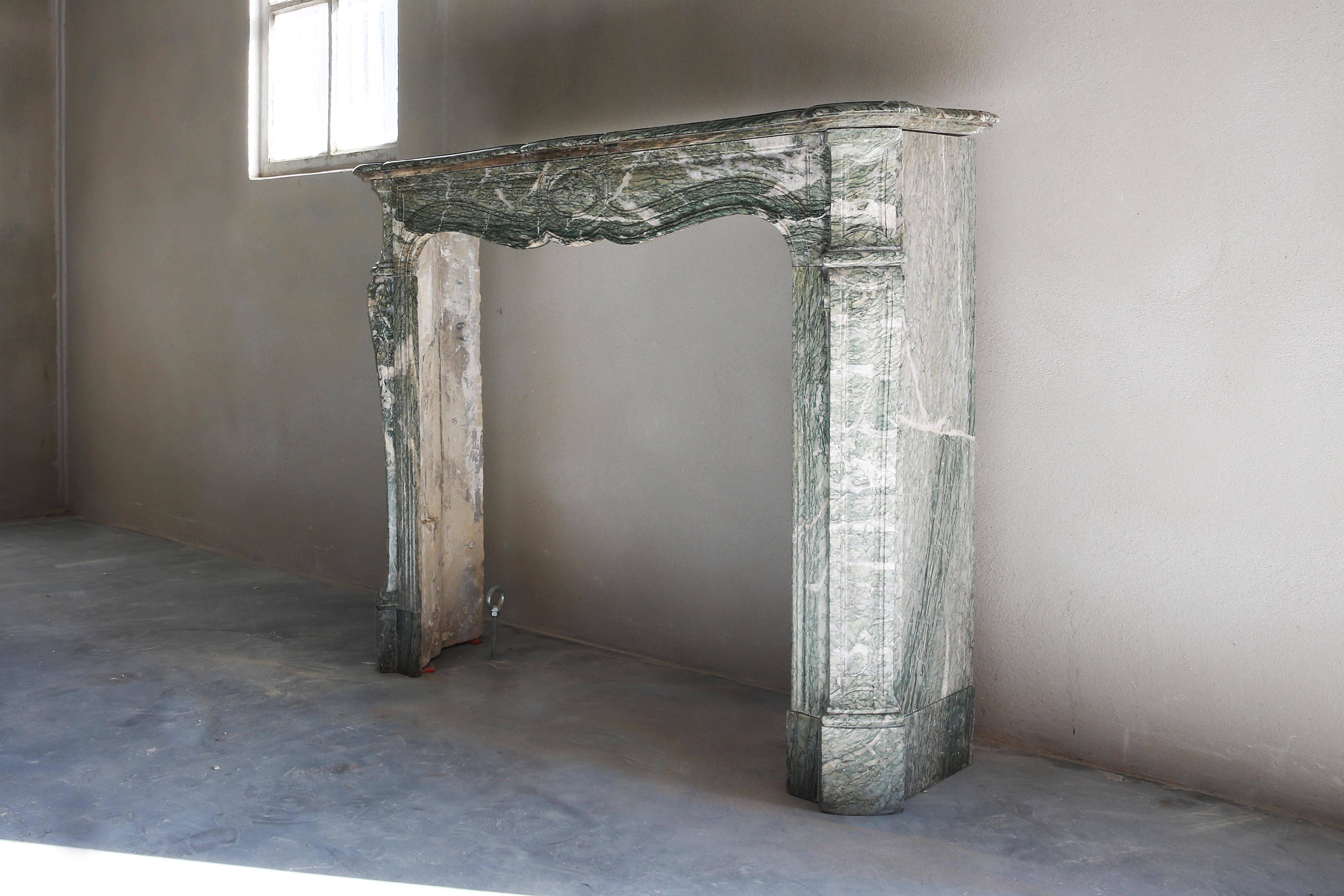 A beautiful and elegant marble fireplace in the style of Pompadour. We found this antique fireplace in Paris.