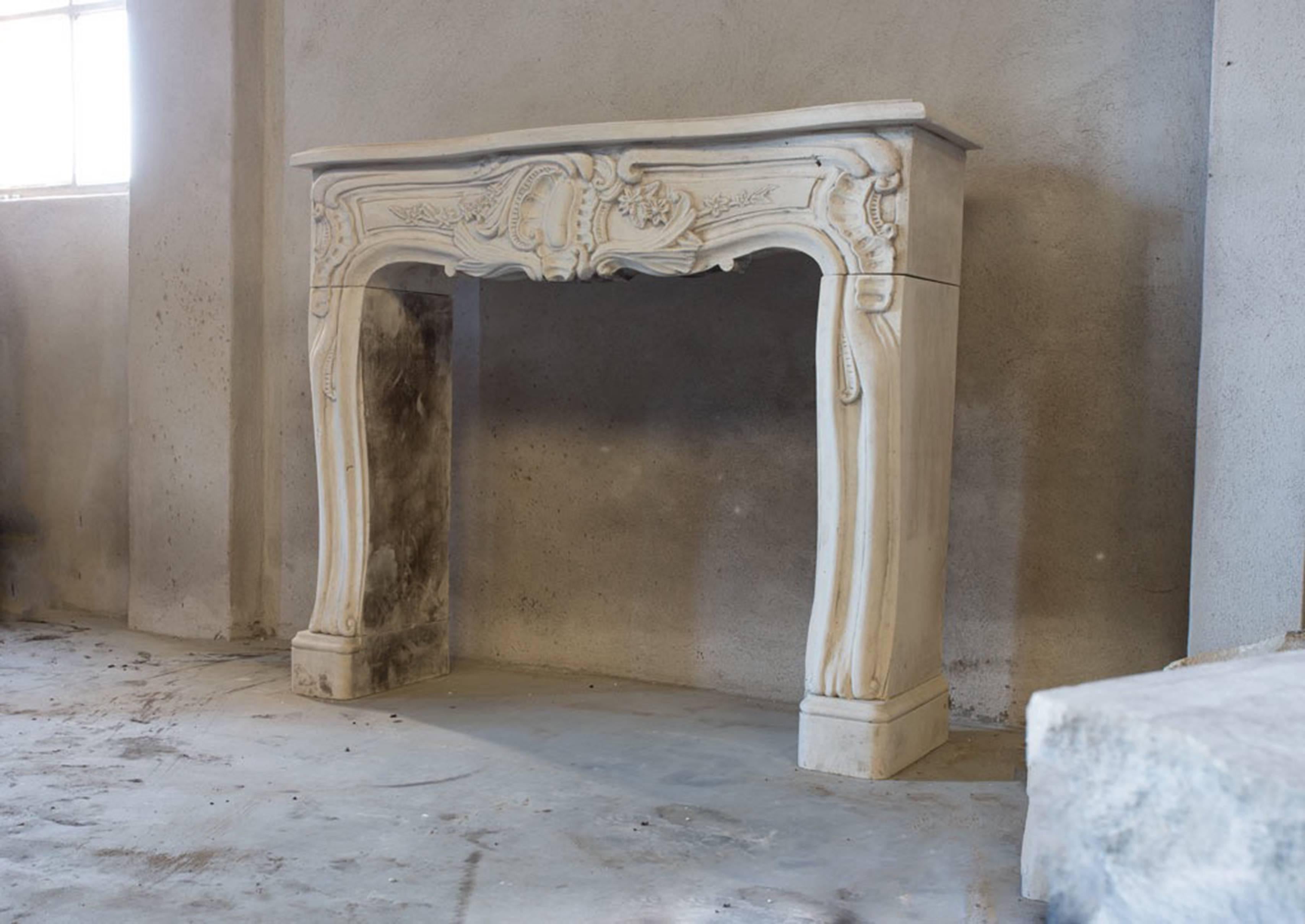 A very unique and classic antique fireplace with a lot of ornaments of limestone in the style of Louis XV.