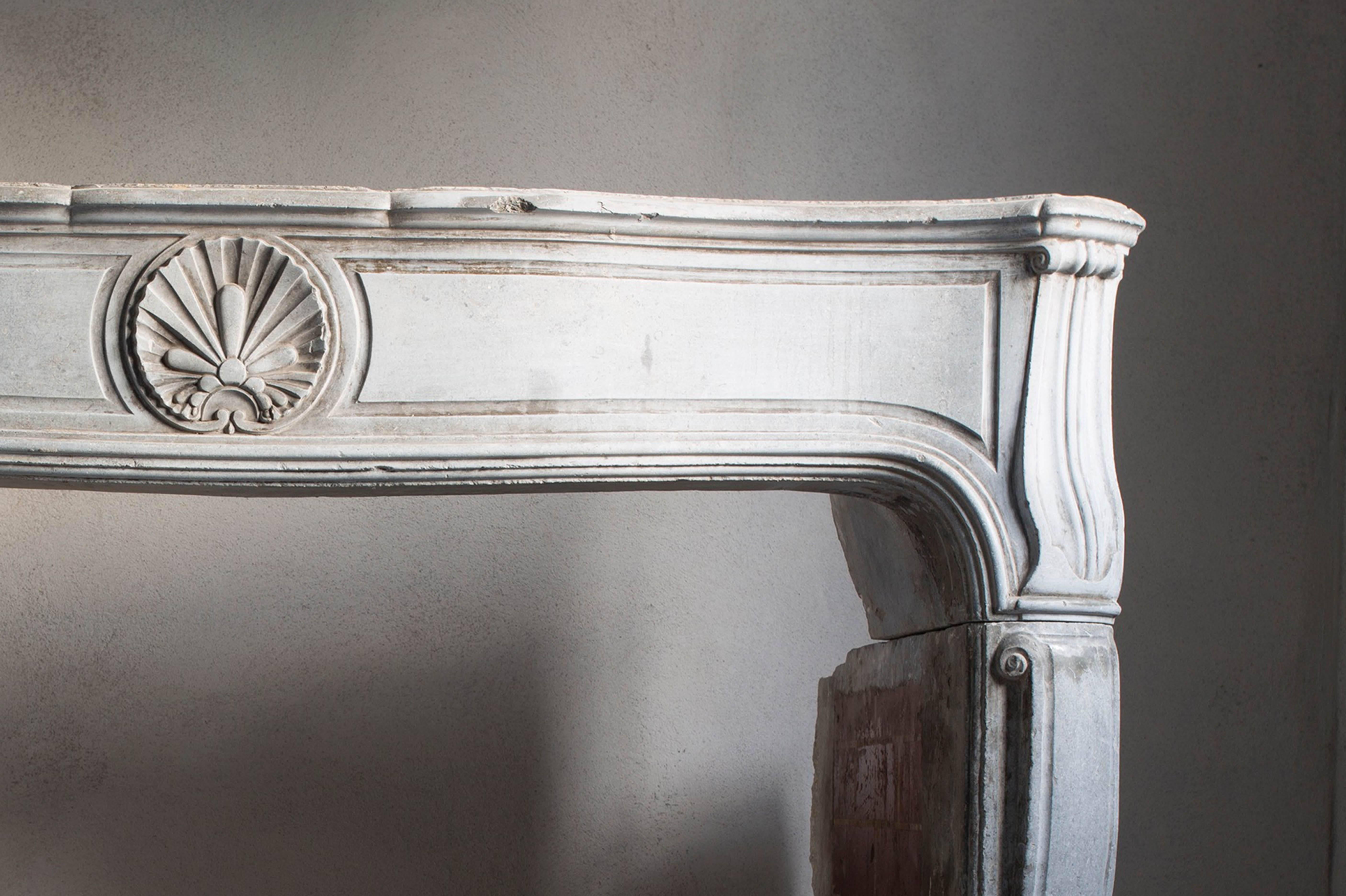 Very charming antique fireplace of marble stone of the 19th century in the style of Louis XV.