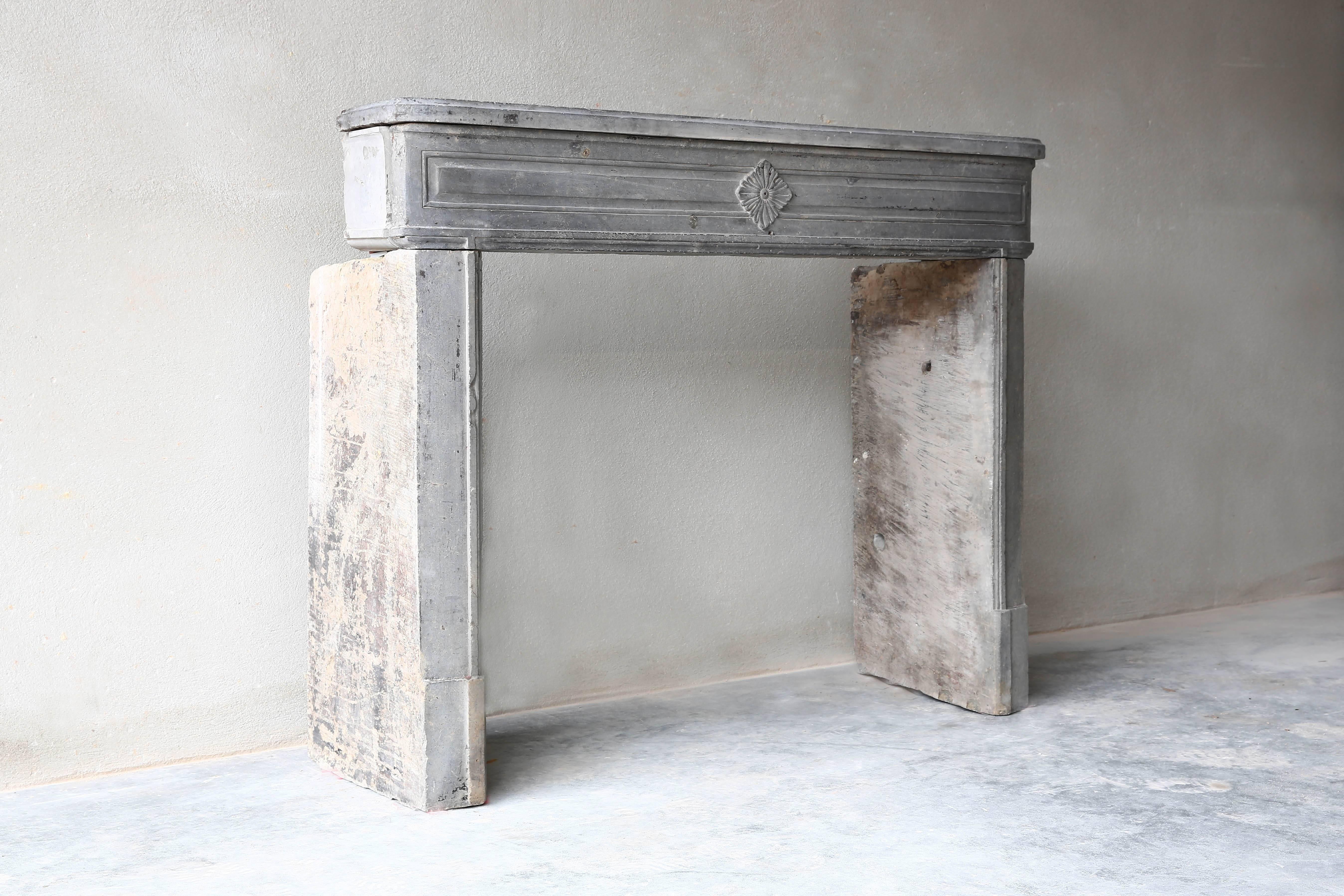 Charming antique fireplace of grey marble-stone 