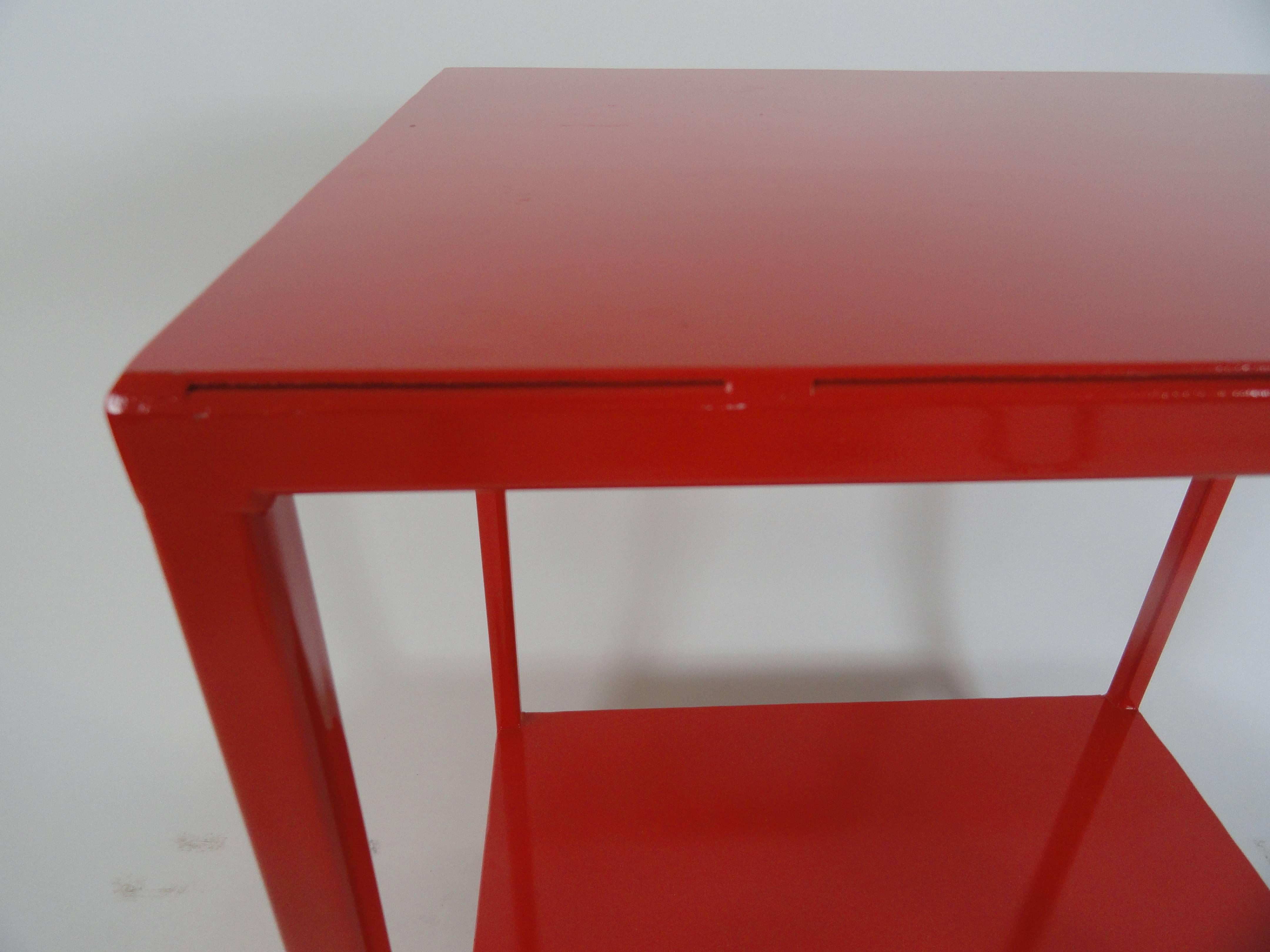 In the manner of Billy Baldwin side table, two tiers, made of metal with red enamel finish. Also available in white and natural. Red pair and white pair available now.