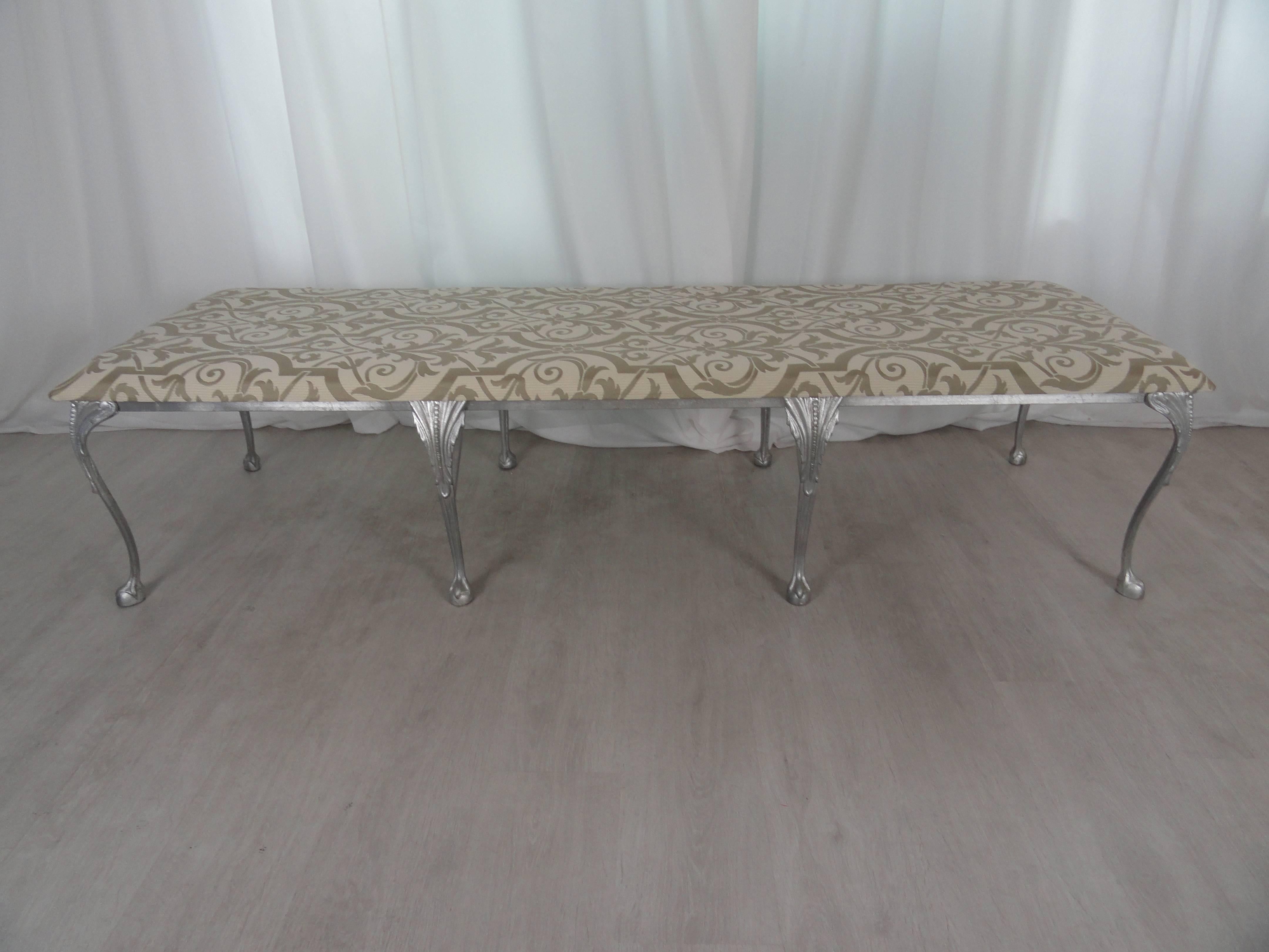 Neoclassical style metal and upholstered bench. Eight leg bench with ball and claw legs in silver finish. Upholstered in contemporary damask. Large-scale.