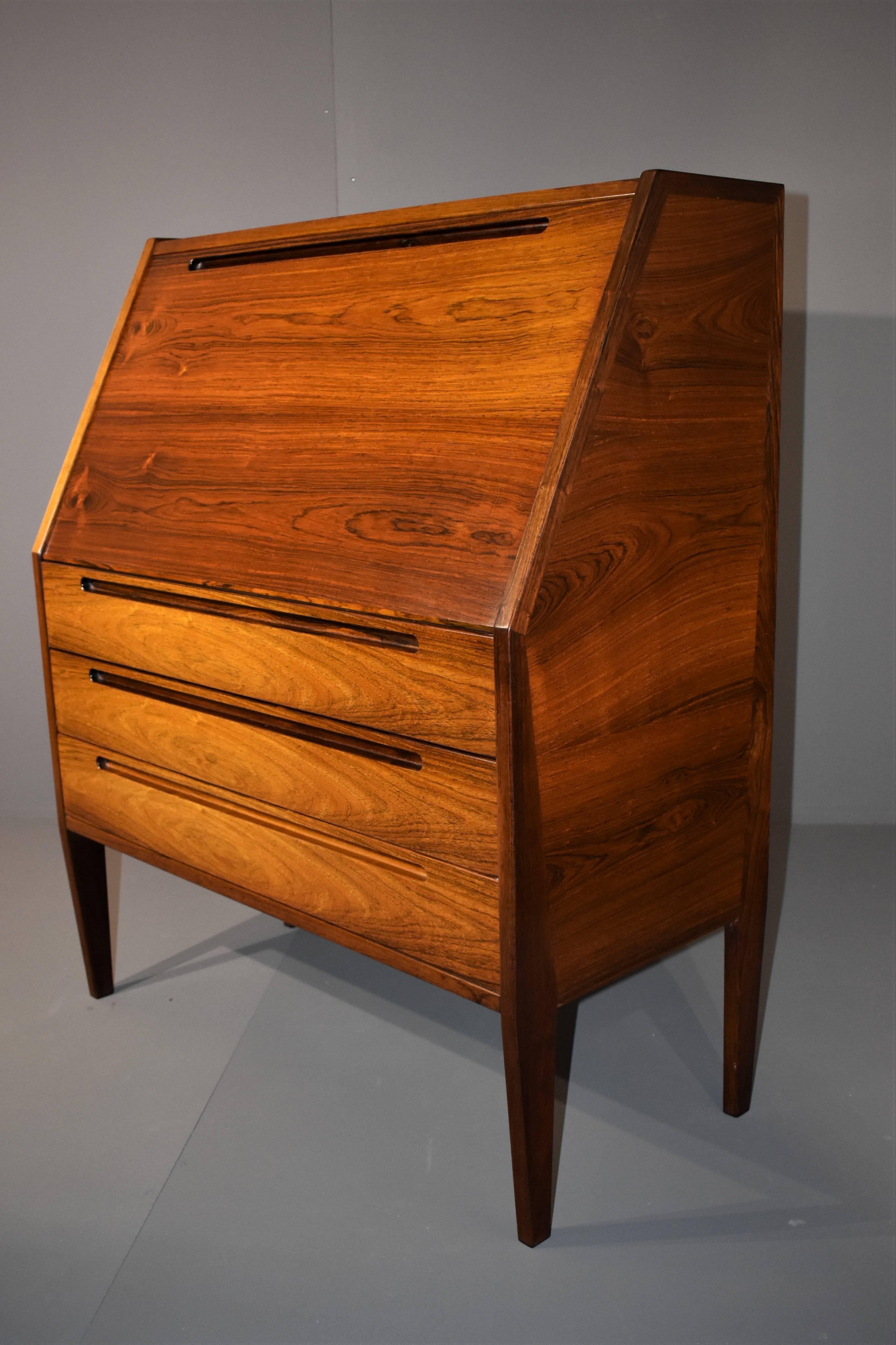 Beautiful Bureau from the 1960s in rosewood, designed by Niels Jonsson.
It has three large drawers and one trap door. On each side both feet form at modern rosewood frame from the ground to the top.
The bureau is in exellent original condition.