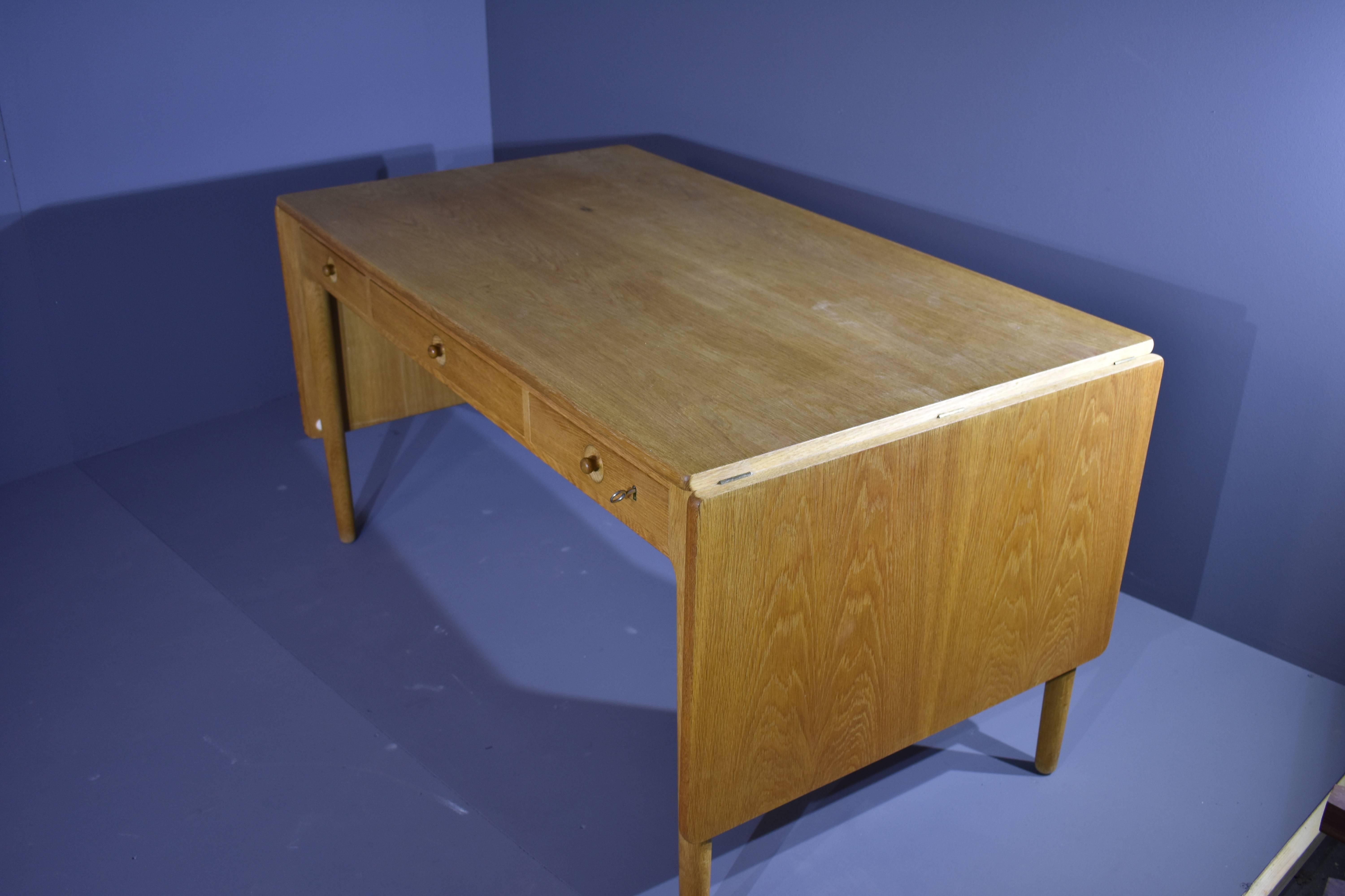 Hans J. Wegner desk AT-305.
The desk is made in oak and has two drop-leaves, front with three drawers, one with pen compartment inside. Key included.
Designed in 1955, manufactured and branded by Andreas Tuck.