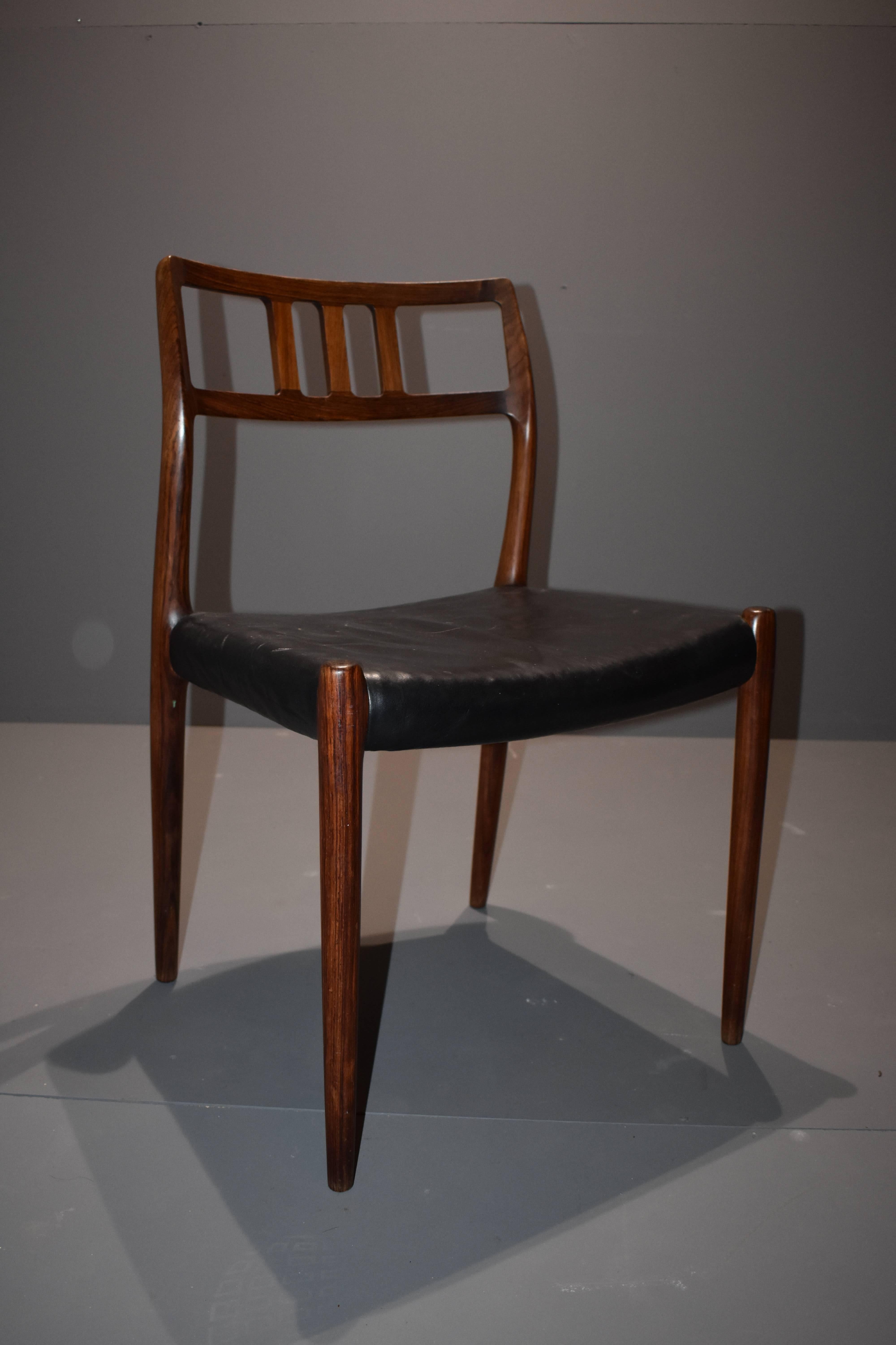 Niels Otto Møller rosewood dining chairs model 79, set of four, with black leather upholstery. One chair has a little bit thicker upholstery. The leather has some patina consistent with age and use.
Frame in rosewood with stunning details.