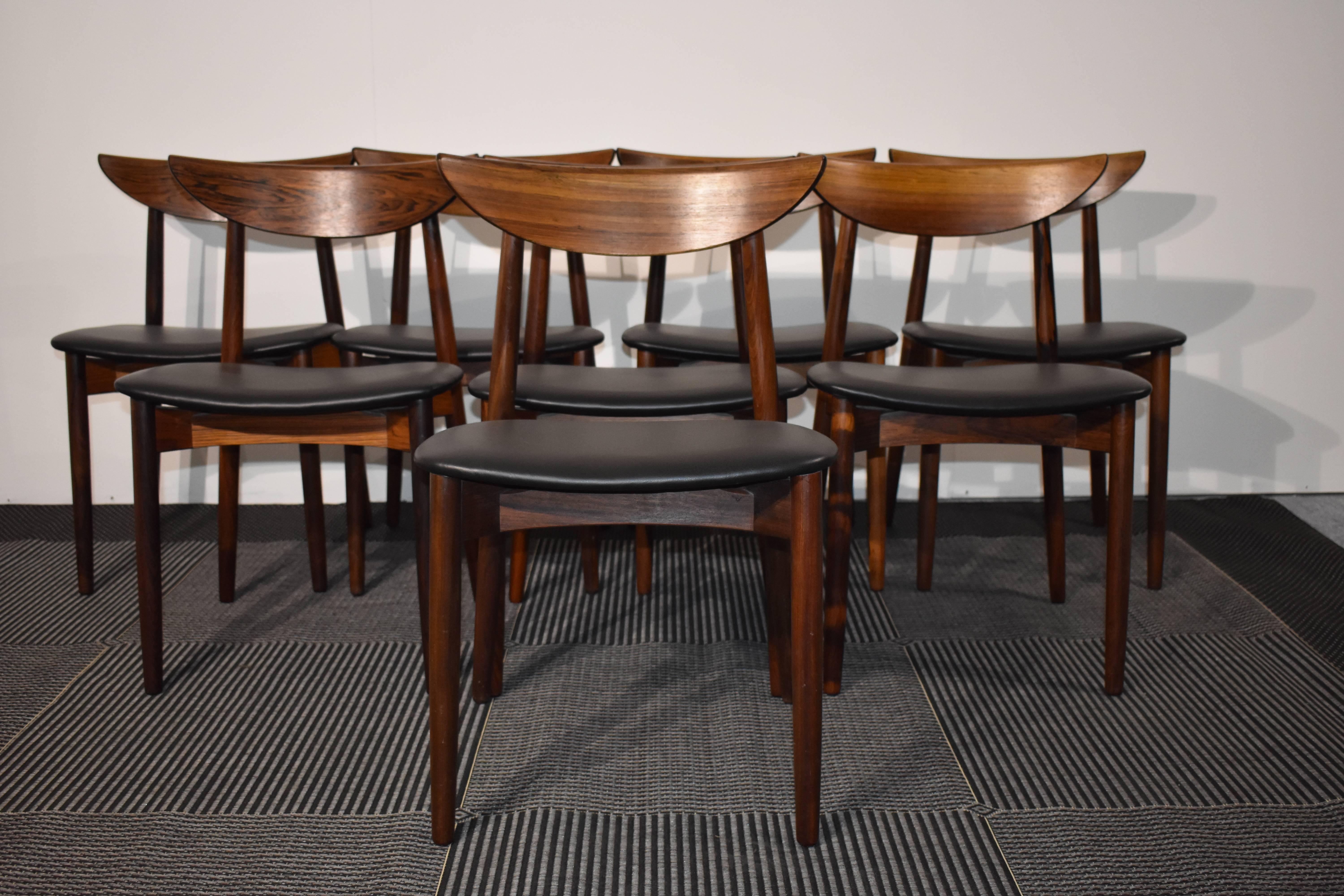 Set of eight stunning dining chairs in rosewood, designed by Harry Ostergaard. Upholstery in new black leather from Sørensen. The chairs are in very good condition. 

  