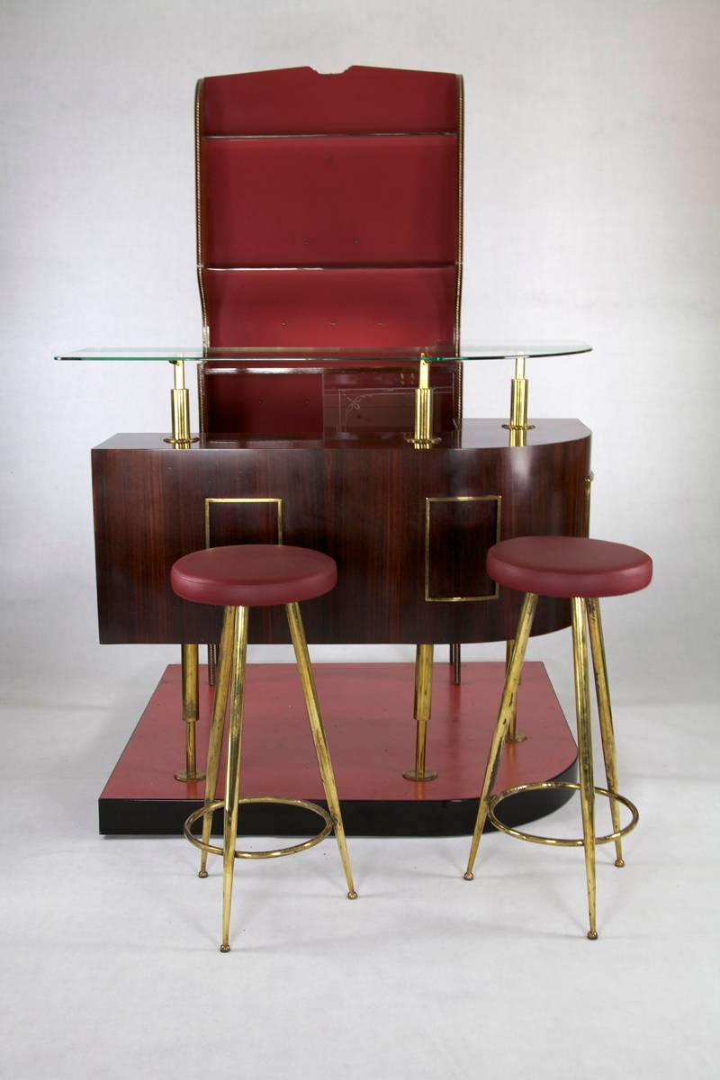 Italian bar set was manufactured in the 1950s. It consists of a rosewood bar, a separate open front cabinet, two stools and a base piece on which the cabinet and bar are set.

Measurements (H/W/D): Cabinet: 187 x 82 x 26 cm. Bar: 110 x 133 x 140