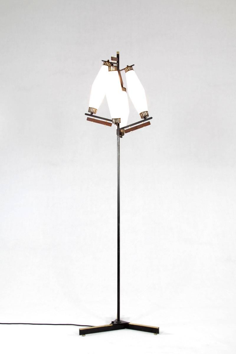 A stylish addition to any interior, this floor lamp from 1960s Italy features four opaline glass shades, creating a soft and inviting glow. Its body is crafted from lacquered metal, accentuated with teak and brass details for a touch of warmth and