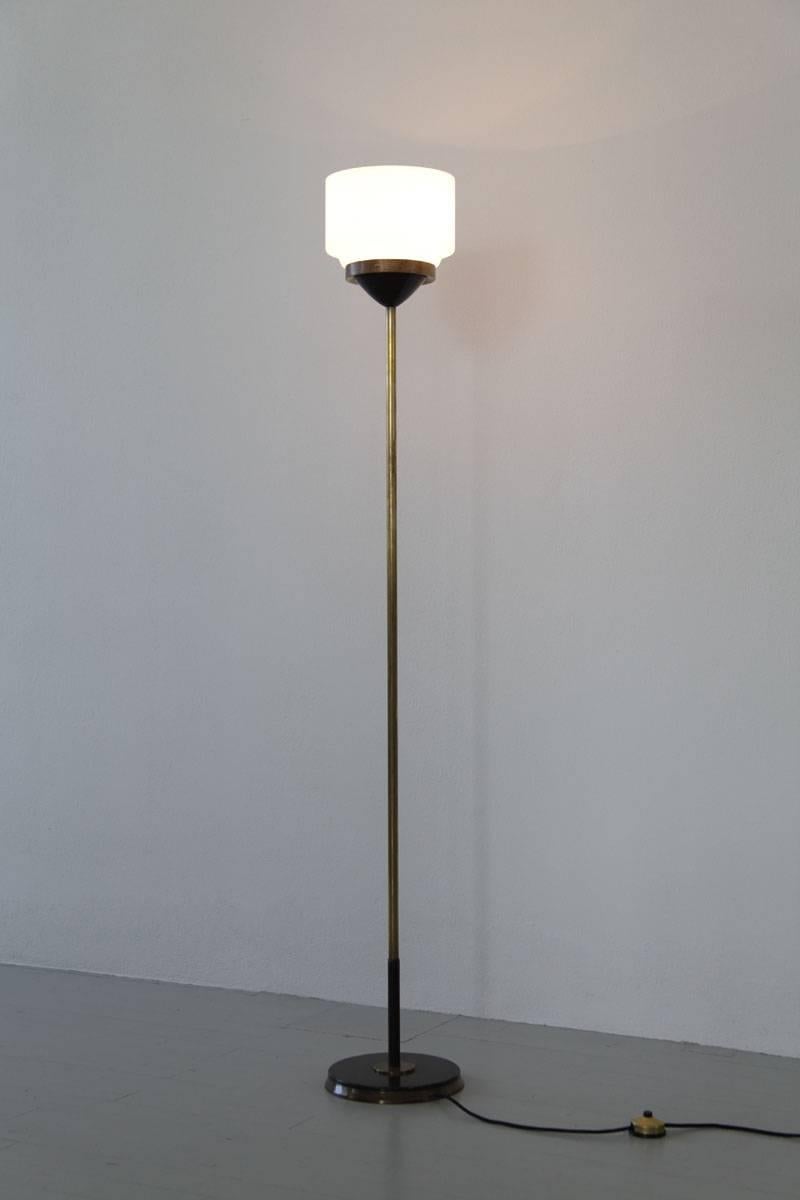 A gem from the 1960s, this floor lamp is a product of Lumi Milano, Italy. Crafted with precision, it features a blend of materials including cast iron, lacquered aluminum, brass, and satinated opaline glass elements. Adorned with its original label,