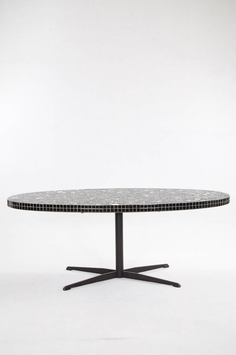 A striking piece from the 1960s, this oval mosaic table features a captivating design with high-gloss white and black stones. Crafted in Germany, its base is constructed from blackened iron, adding to its modern appeal. Maintaining a good vintage