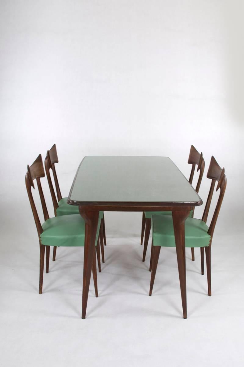 Italian midcentury table with six chairs in the manner of Ico Parisi. Light turquoise glasstop and light turquoise imitation leather in its original upholstery.