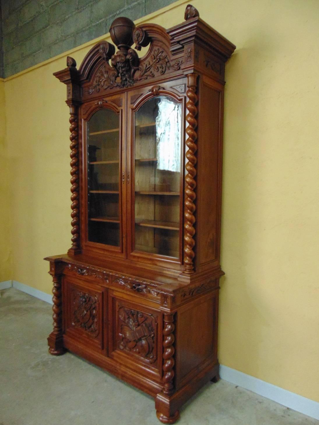 One of the finest quality all original hand carved double door bookcases we have had for many a year ! In solid walnut surmounted by a globe of the world under which is a magnificent Green Man masque over two glazed doors with original glass