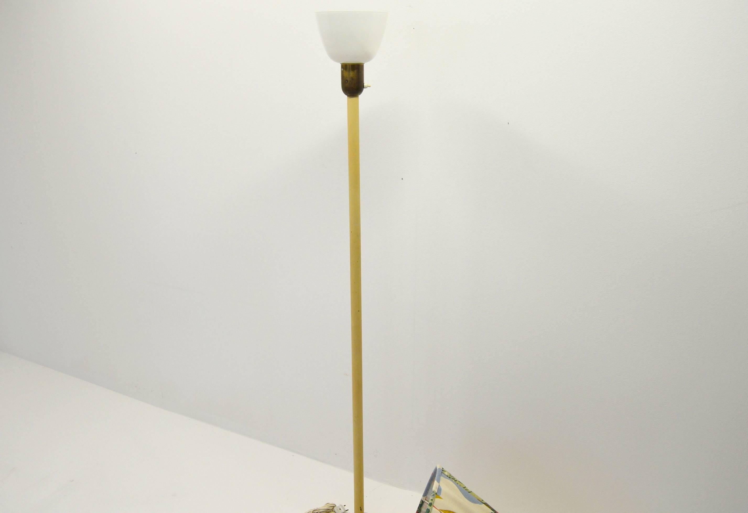 Floor lamp most likely produced in Sweden for ASEA or Firma Svenskt Tenn.

– Bar of cream-colored metal, feet of brass, uplight glass shade on top and fabric lamp shade sewn by hand
– Mid century
– Excellent vintage condition with signs of usage