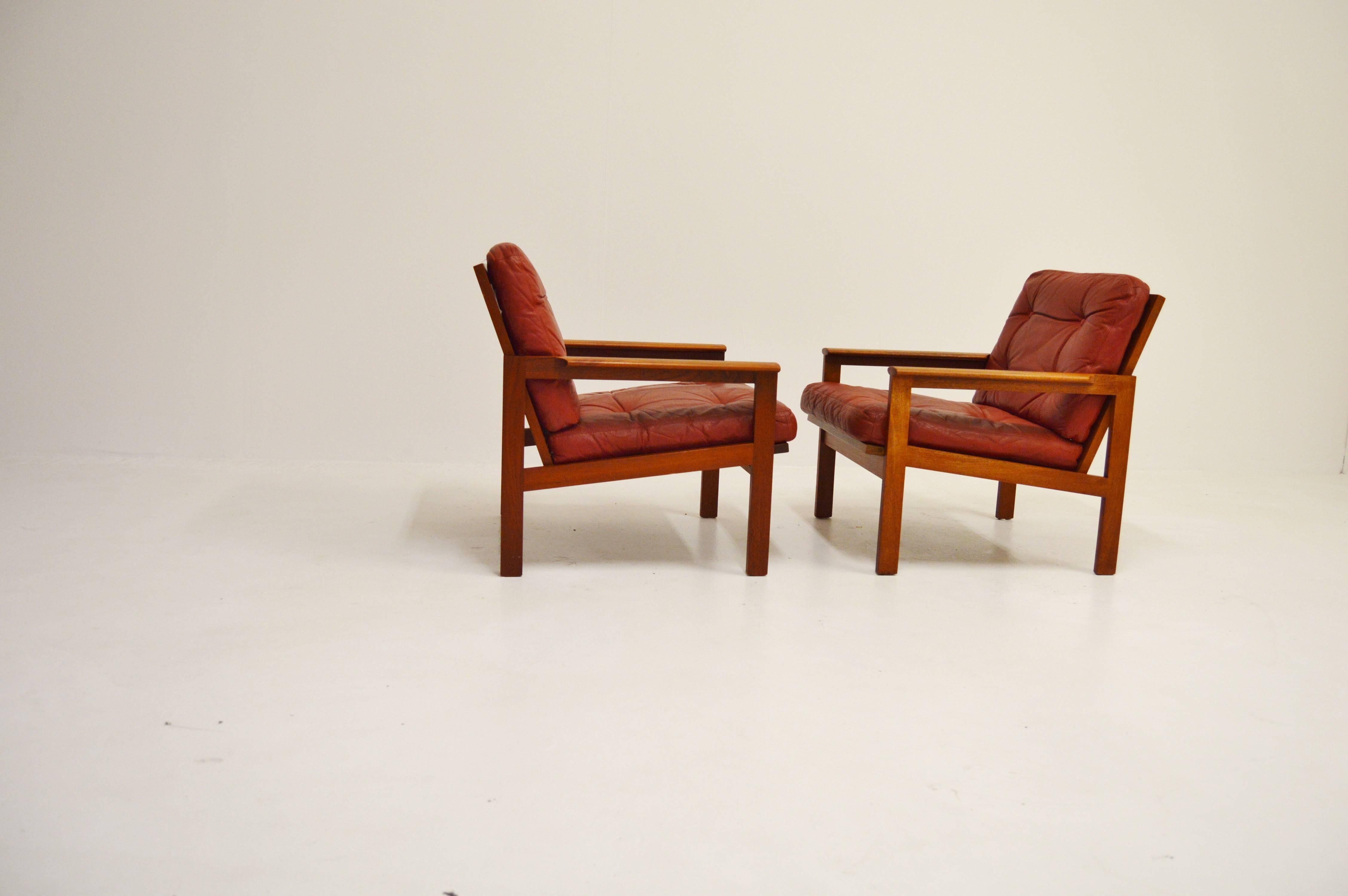 A pair of lounge chairs made of teak. Red leather coushions with deep-knotted buttons.
Designed by danish designer Illum Wikkelsö in the 1960s.