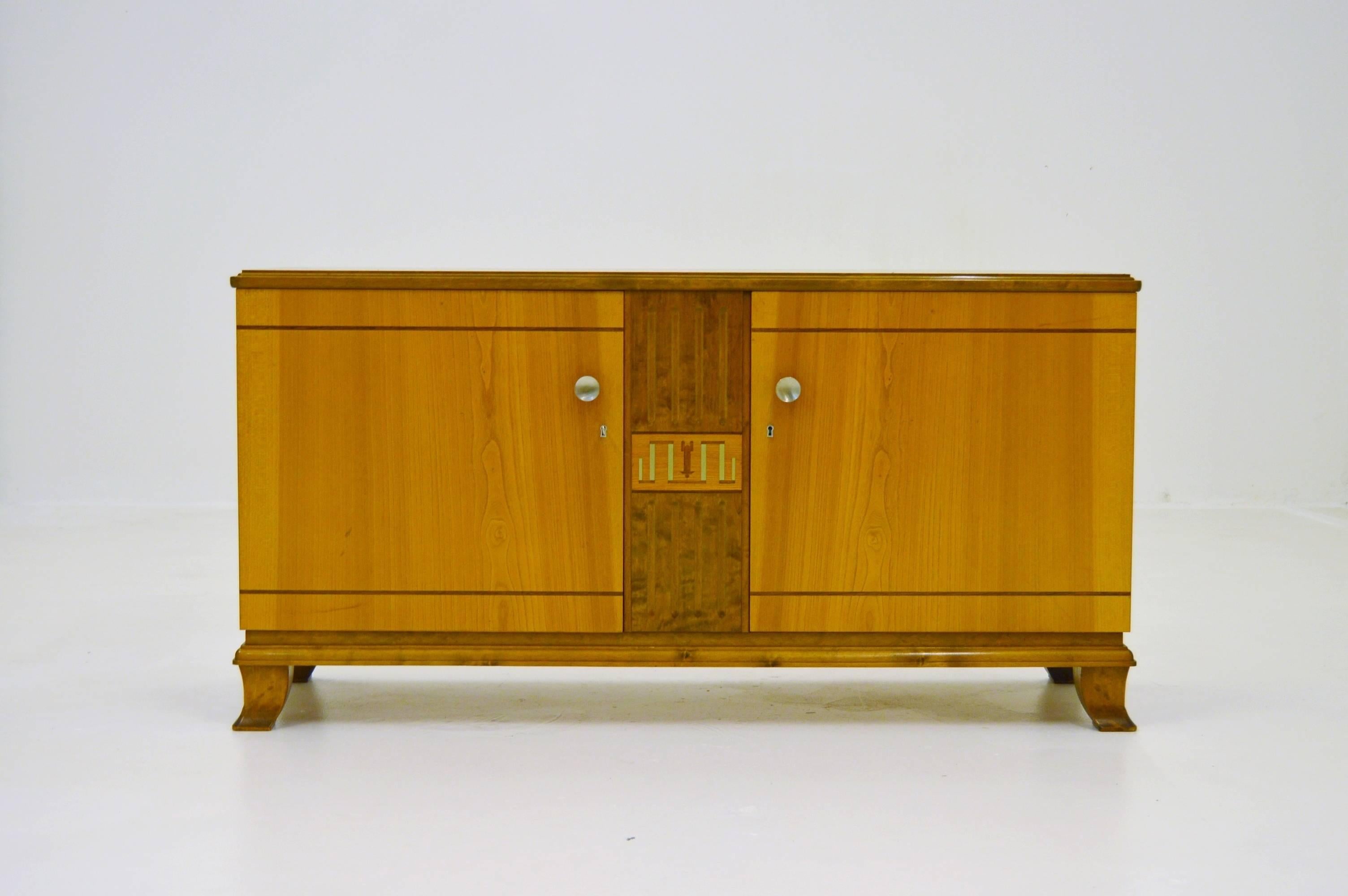 Very elegant Swedish sideboard from circa 1940s with intarsia of pewter. Wood base of elm and birch. See how good the handles match with metal intarsia.
Even the keyhole is designed and fits in style.